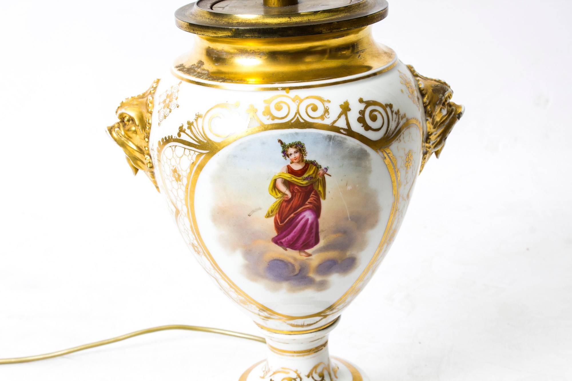 A beautiful French porcelain lamp with hand-painted scenes and delicate gilt decoration, dating from 1850. 

The lamp features a pair of oval panels, one with a hand-painted classical deity in the clouds and the other painted with wild flowers, each
