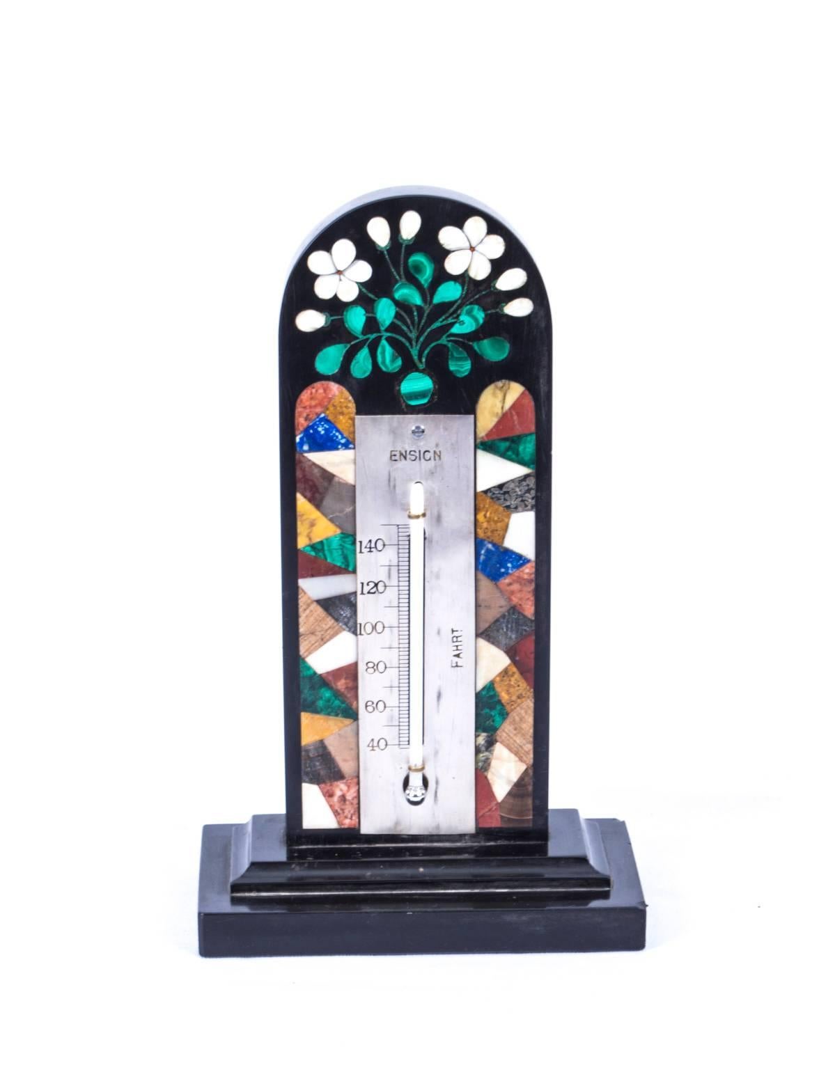 This is a wonderful Derbyshire Ashford marble thermometer, circa 1880 in date.

The thermometer features a silvered register engraved with ENSIGN, FAHRT and a central mercury tube.

The arched cresting is beautifully inlaid with a Pietra Dura of