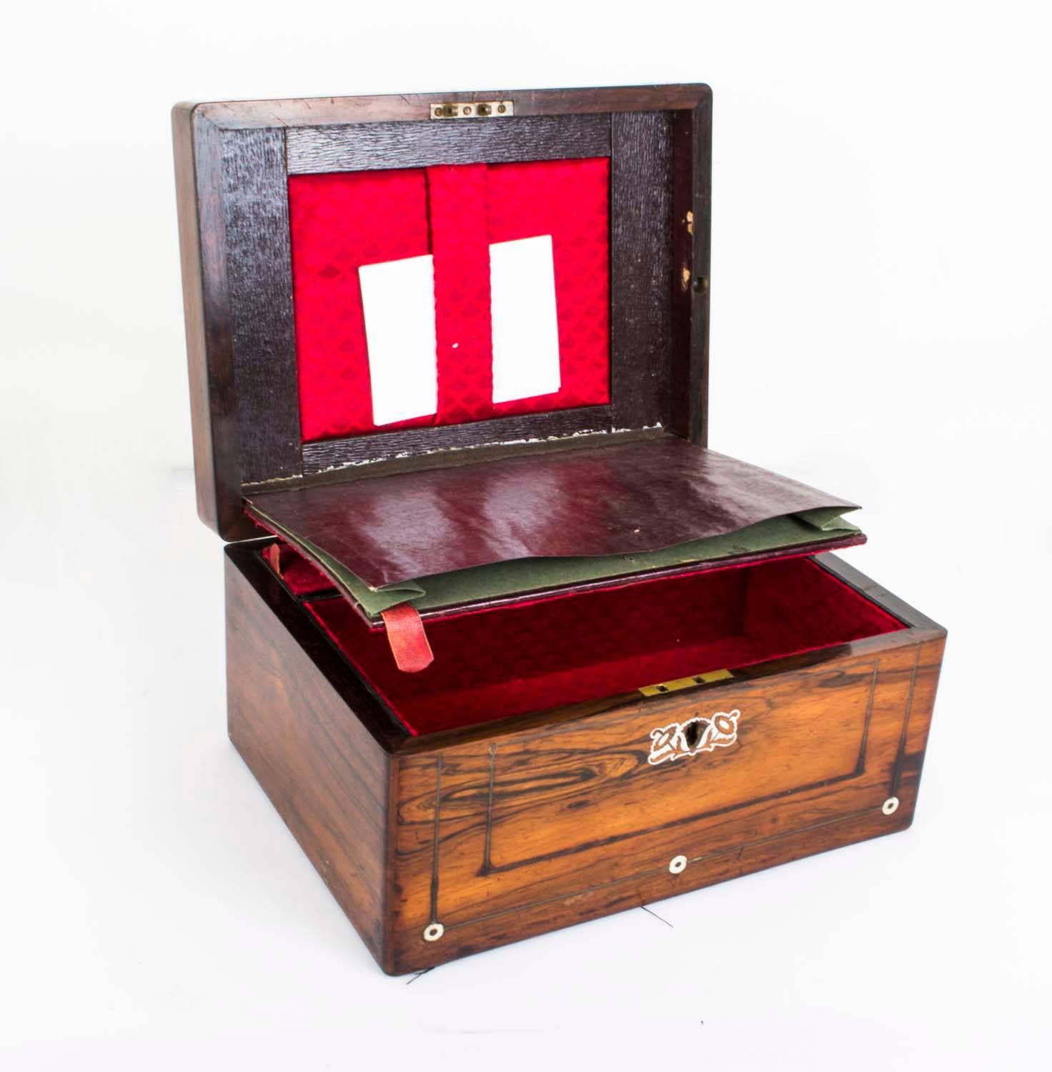 This is a wonderful antique rosewood jewelry box, with mother of pearl and brass inlaid decoration, circa 1840. 

There is a hinged lid which reveals interiors lined with elegant patterned burgundy velvet. The casket has also a separate