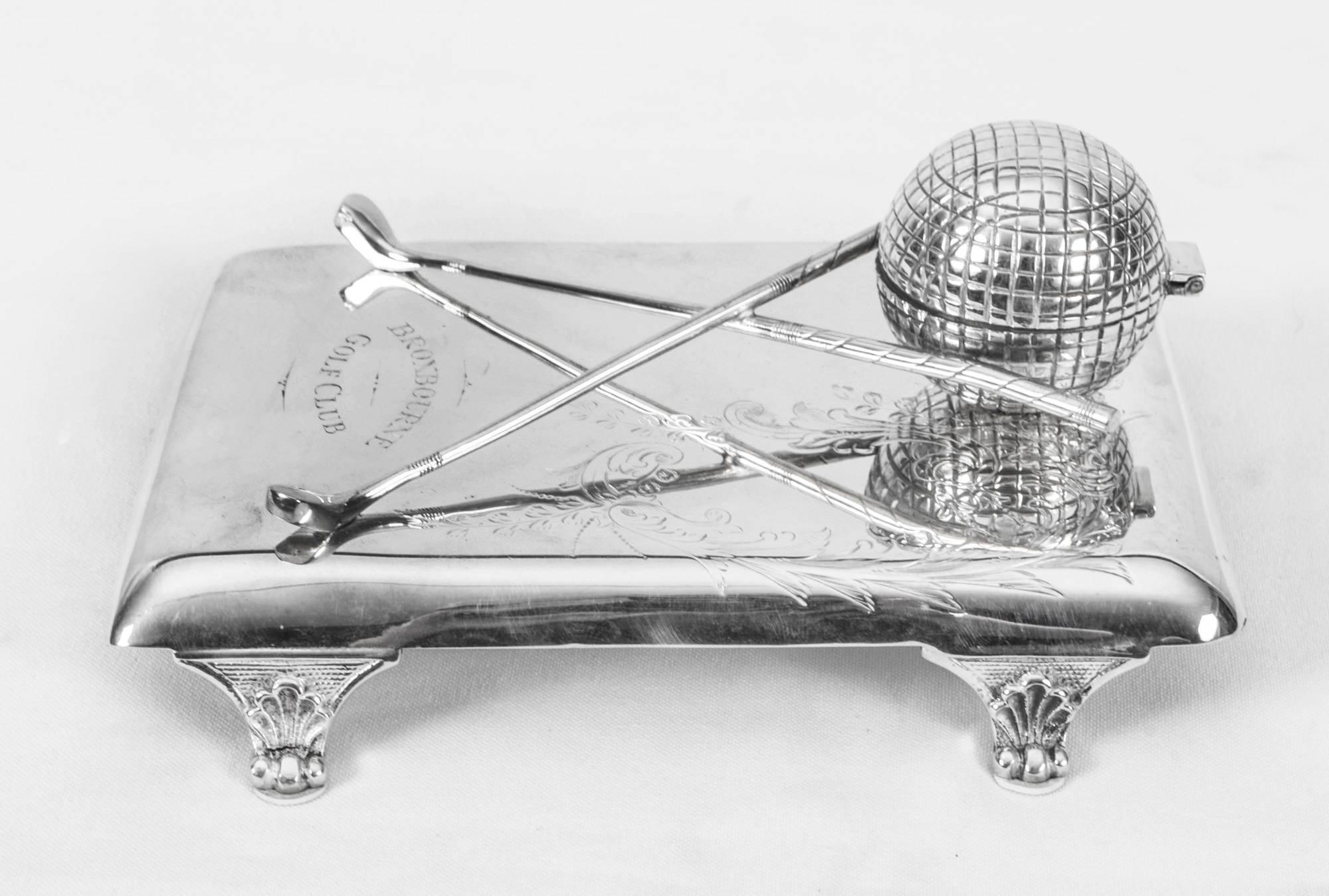 This is a novelty antique Edwardian silver plated inkwell made by Hamilton Laidlaw & Company, circa 1900. 
The inkwell features a golf ball with liner for the ink and a pair of crossed golf clubs. The plateau is beautifully engraved with