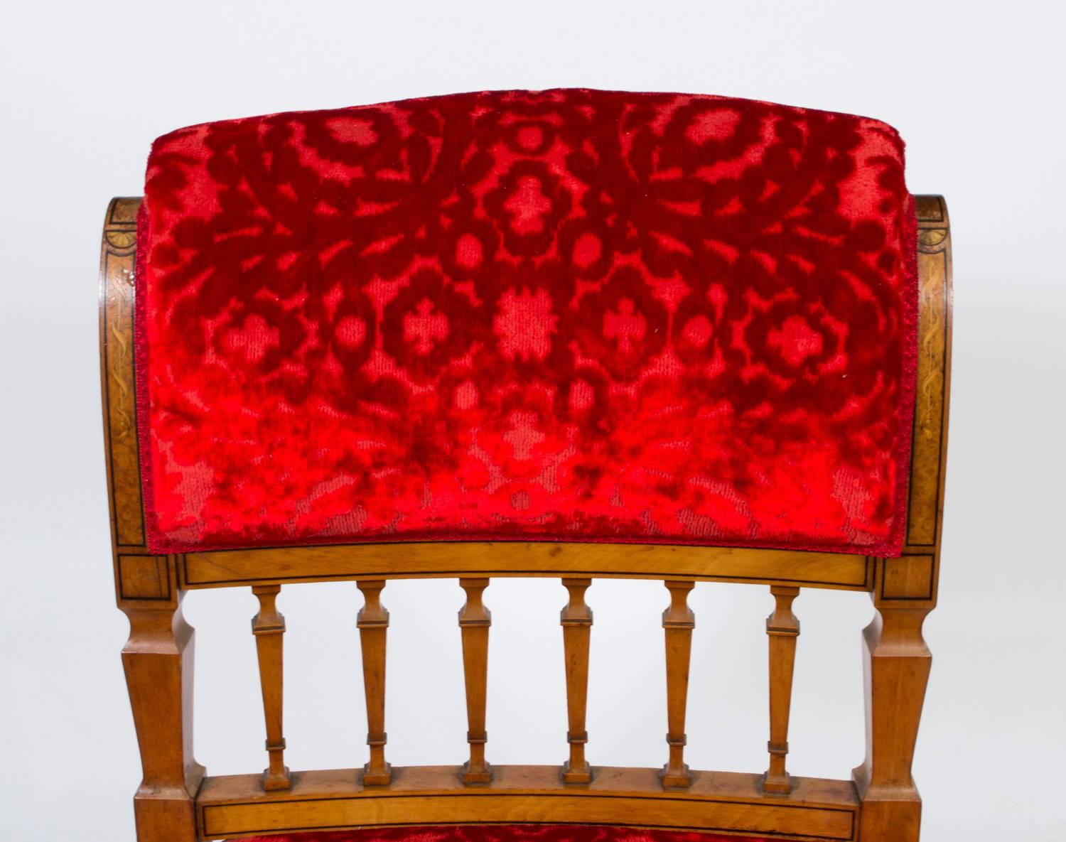This is a lovely antique Victorian nursing chair, circa 1880 in date, made from solid satinwood and beautifully inlaid.

The chair has been beautifully reupholstered in a red velvet fabric with embossed floral patterns in the same colour. 

It