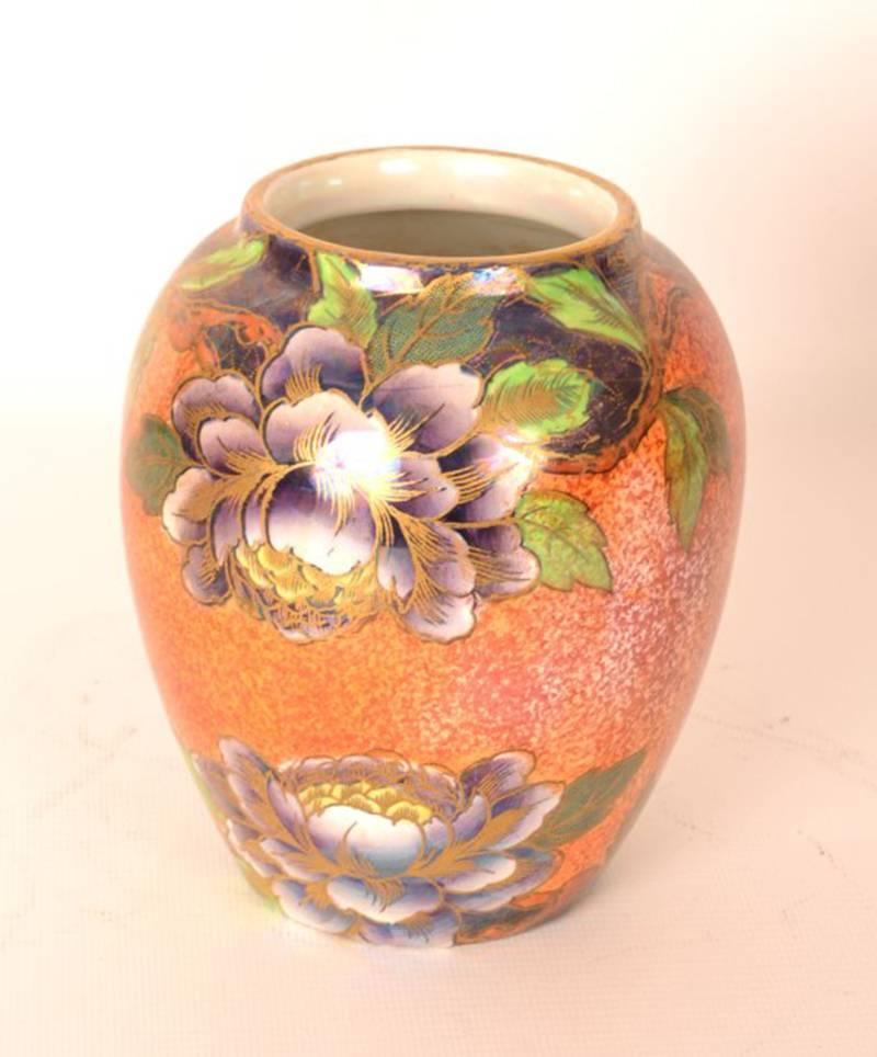 This is an elegant, antique Art Nouveau vase by Maling in the early Peony pattern of purple peonies with gold overpainting on orange lustre ground, circa 1920.

There is a maker's mark on the bottom.

It is a lovely vase which would brighten up