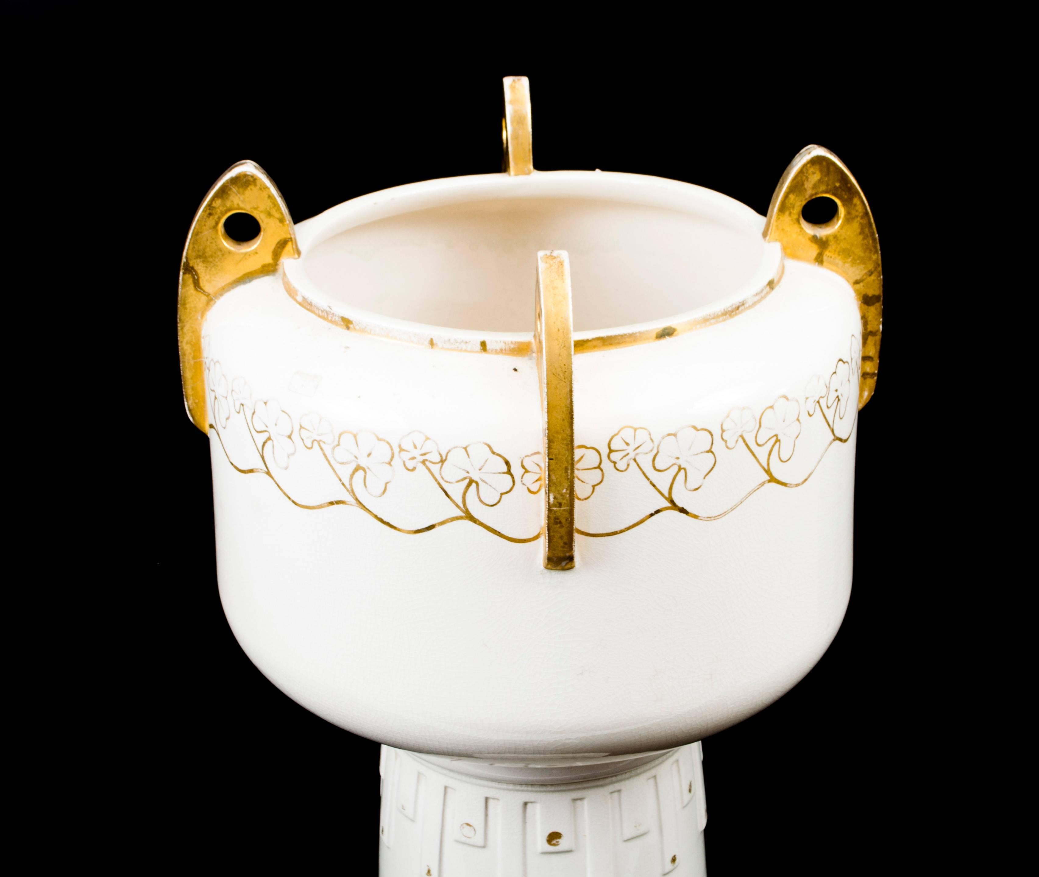 This is a beautiful antique Art Deco jardinière on stand, 1926 in date.

There is a gilded M hallmark on the underside of the jardinière which indicates that this is Minton Porcelain.

It has its original gilded decoration.

It is in excellent