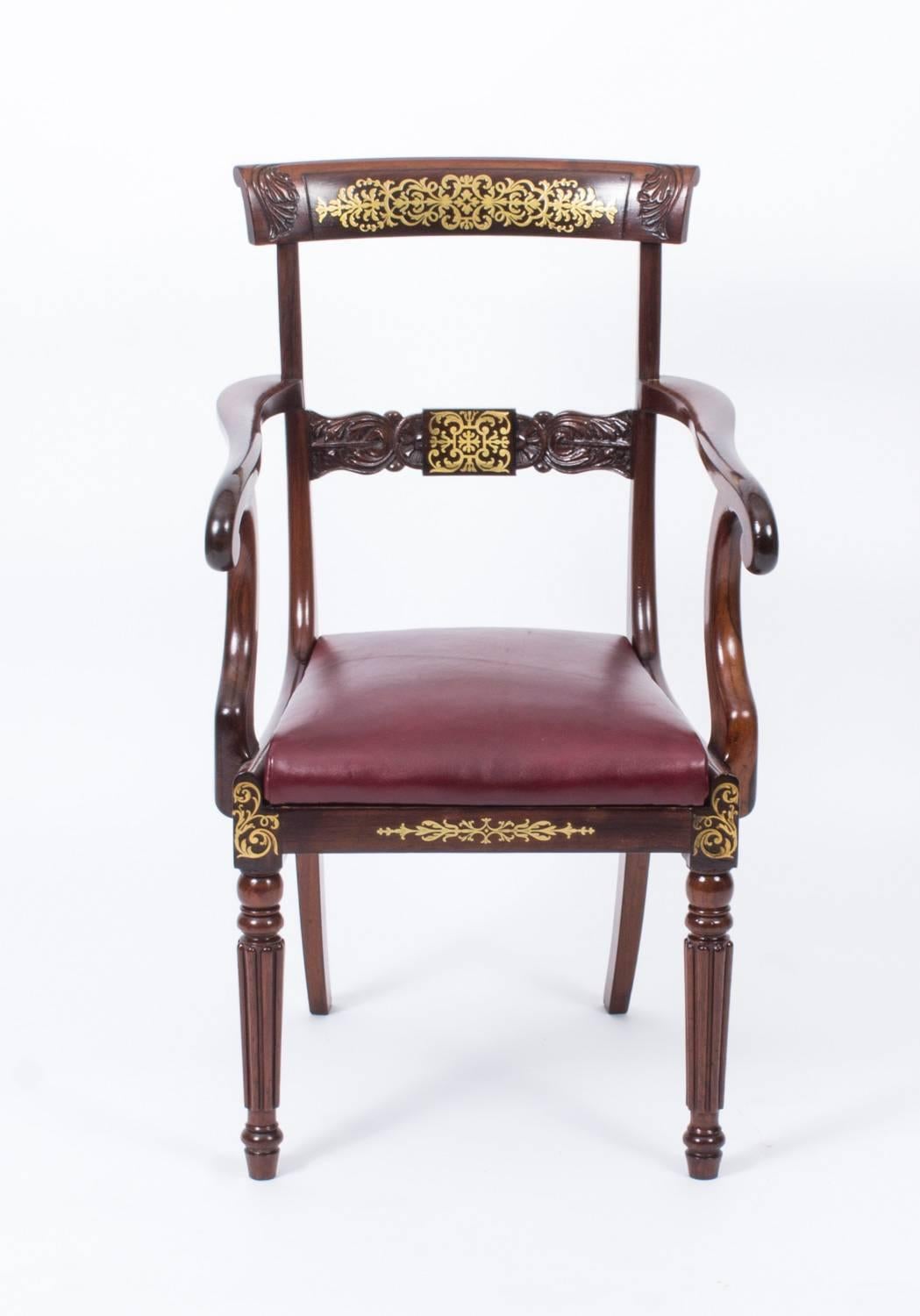 This is an elegant antique Regency mahogany and cut brass marquetry elbow chair, circa 1815 in date.

It has a beautiful curved cresting rail and a central bar profusely inlaid and carved with acanthus, and the pair of downswept arms have elegant