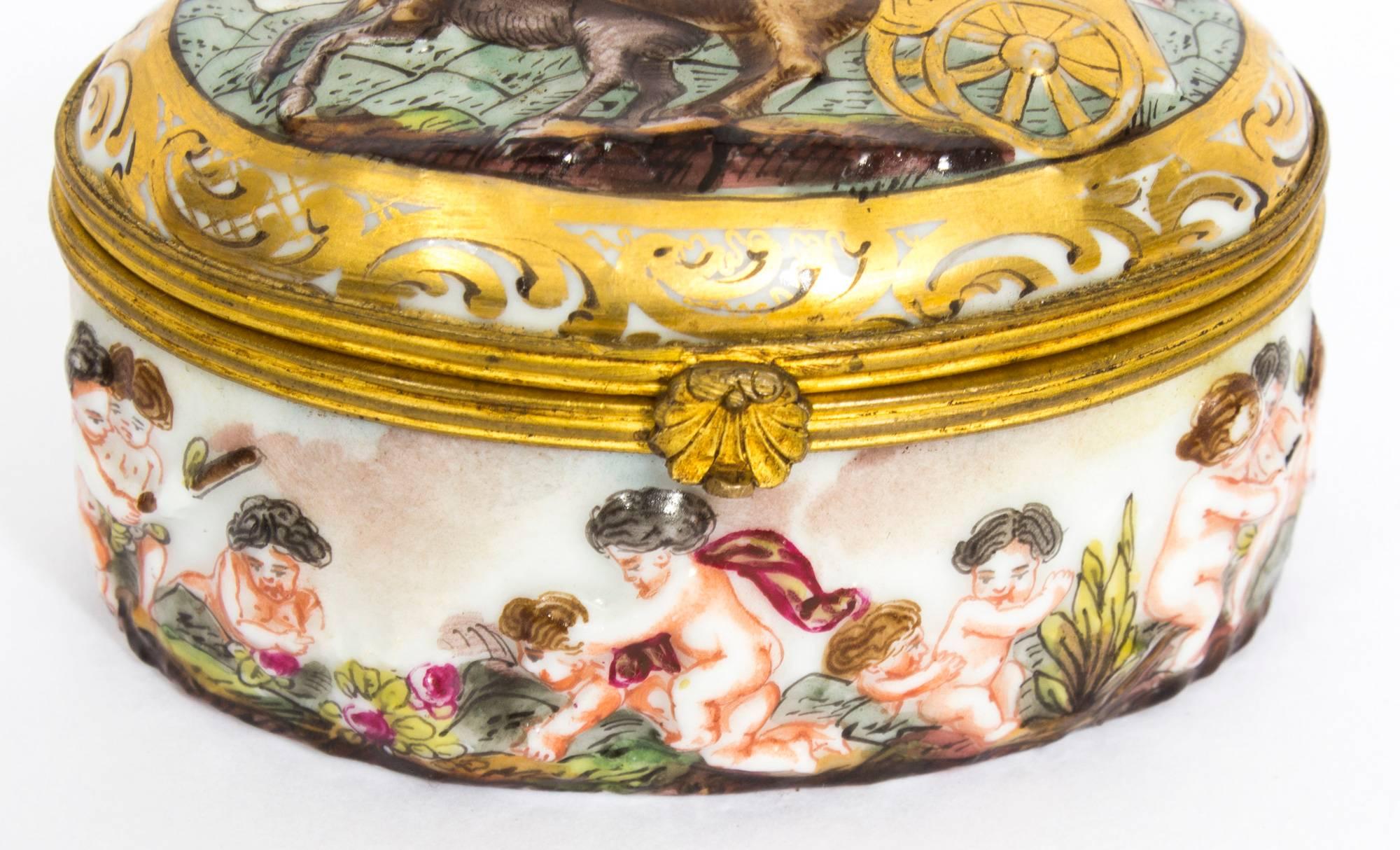 This is a beautiful antique Italian Capodimonte porcelain pill box, 1890 in date. 

It features a chariot scene on the lid, the sides are lavishly decorated with playful putti and it has an attractive omolu border.

The scenes are hand-painted