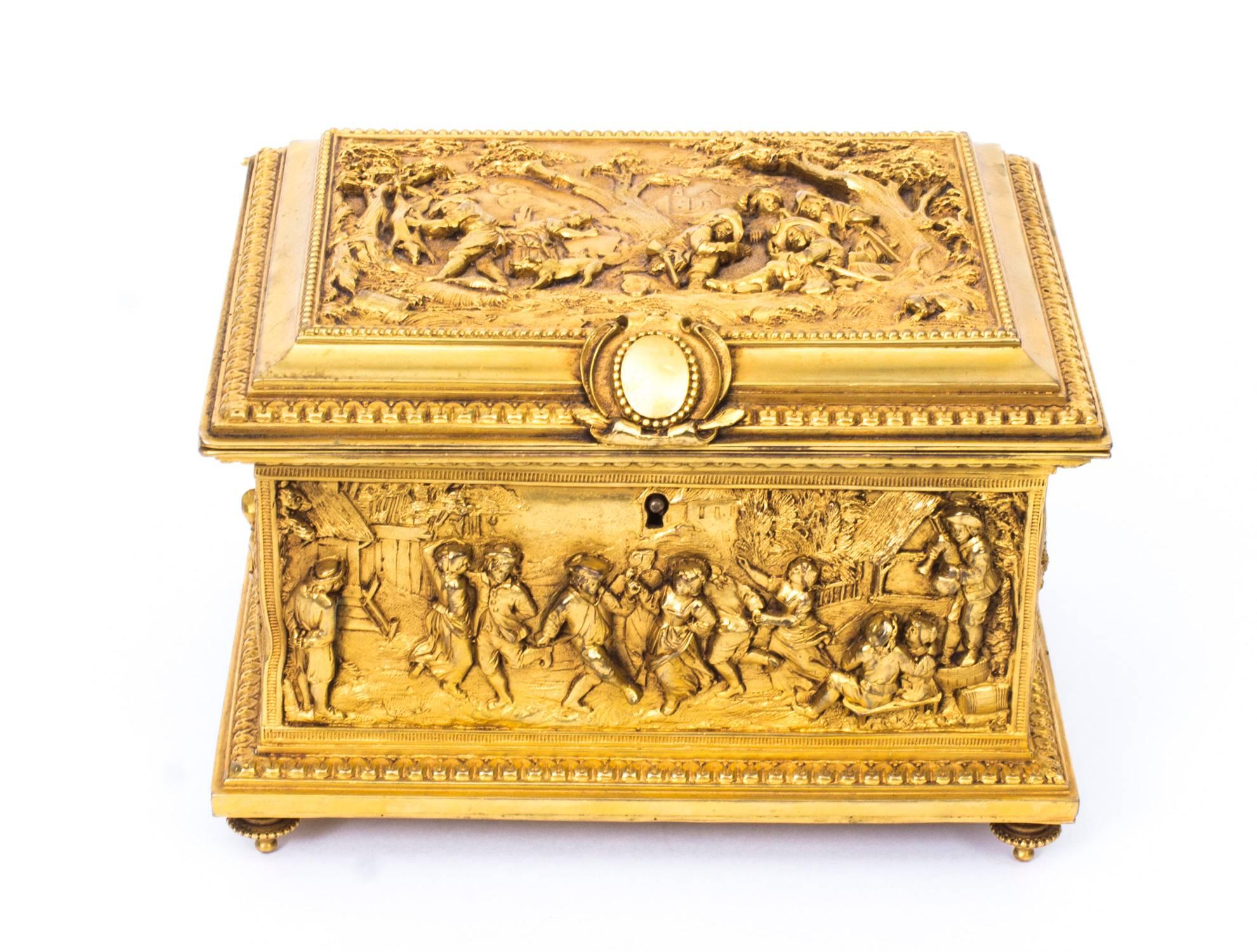 This is a beautiful antique French gilded ormolu jewellery casket, circa 1870 in date.

The top, front, sides and back are beautifully cast in gilt bronze and feature panels of medieval scenes of revellers hunting and feasting. 

The interior is