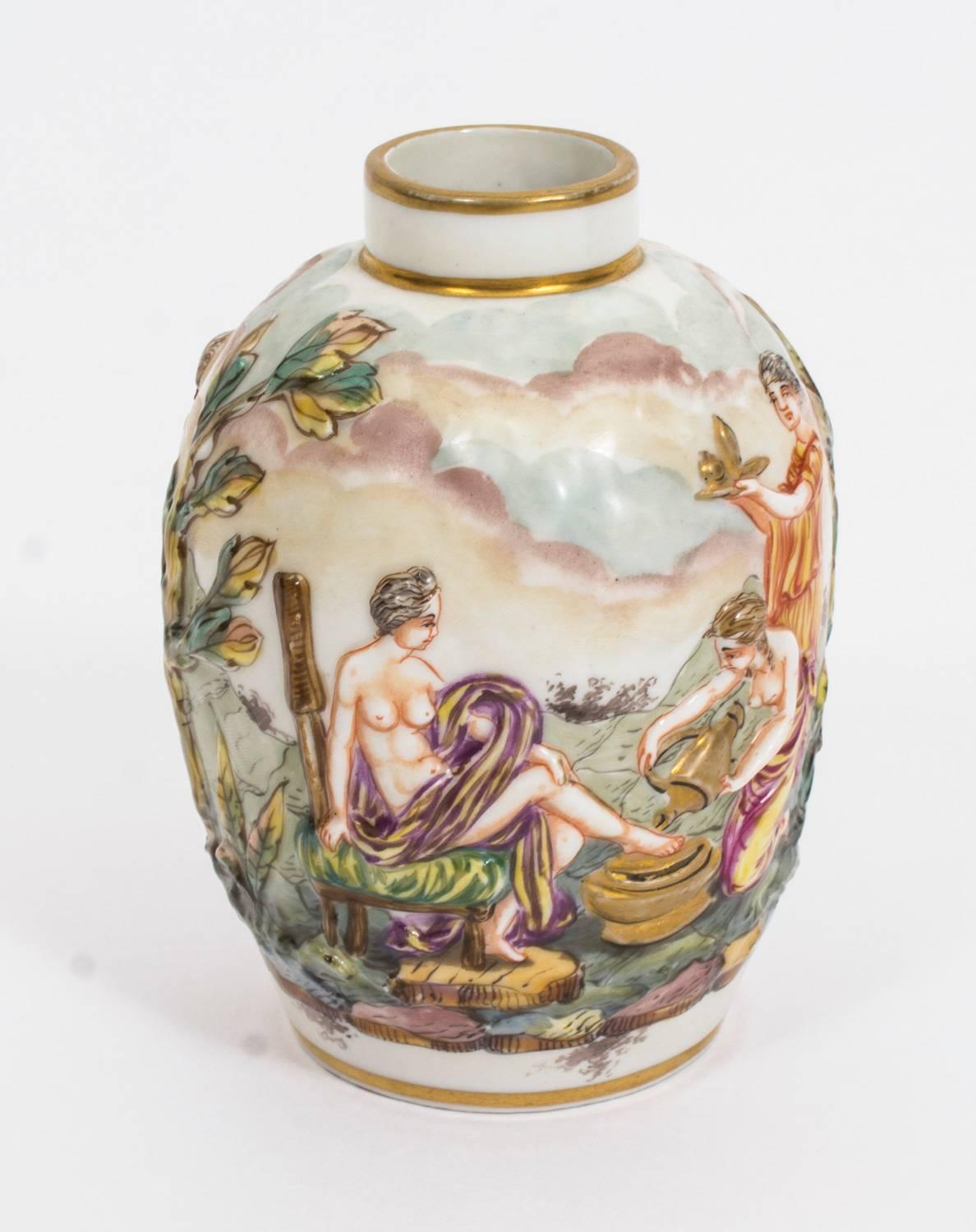 This is a lovely antique pair of Capodimonte porcelain jars, circa 1900 in date.
They feature blue crowned N marks at the bottom which refers to Naples' porcelain.

The urns feature beautiful hand-painted classical scenes in relief of classical