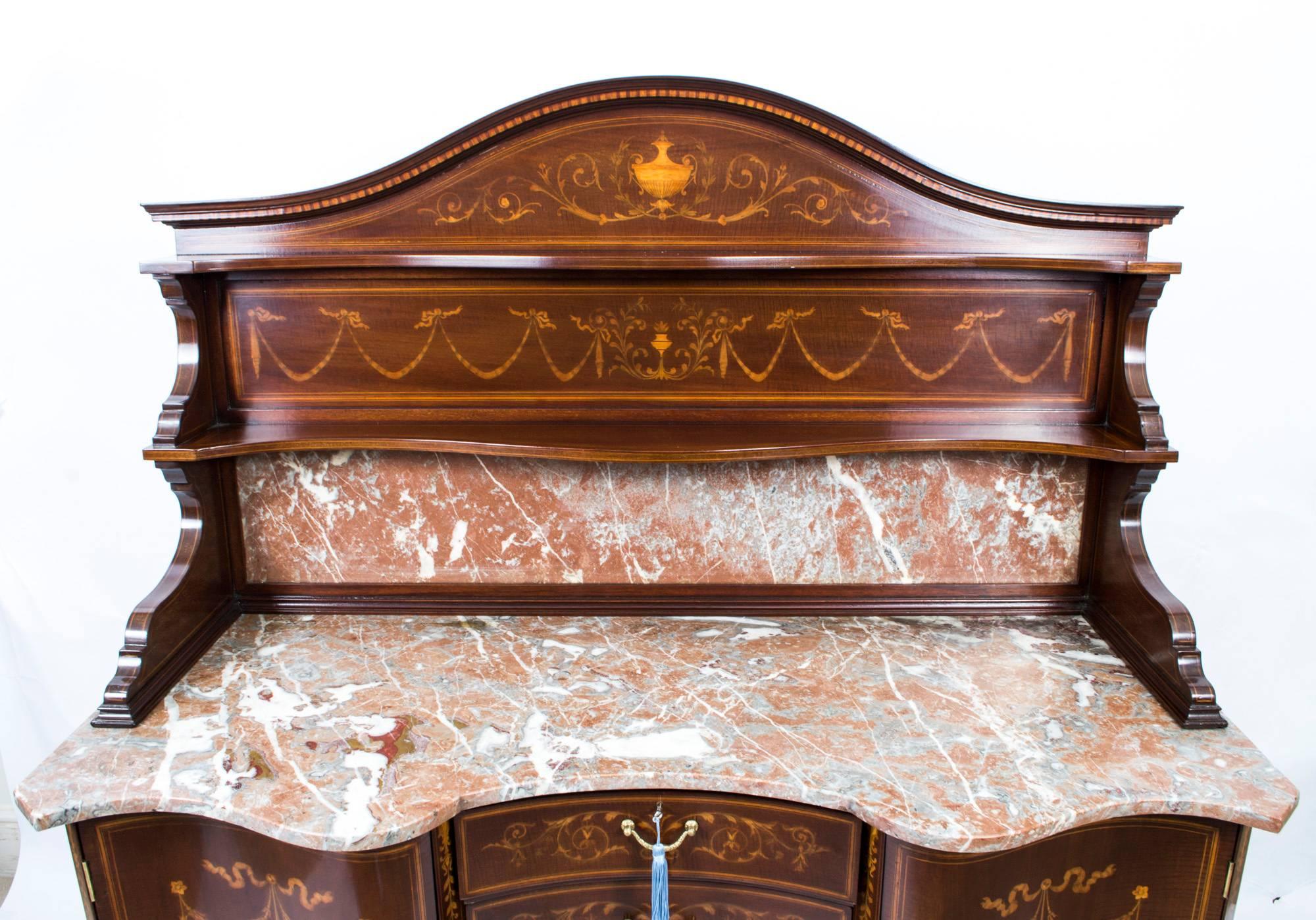 This is a spectacular antique late Victorian mahogany and floral marquetry washstand by the renowned cabinet maker and retailer Edwards & Roberts, circa 1880 in date.

It is inlaid with a beautiful marquetry of scrolls and foliage in satinwood