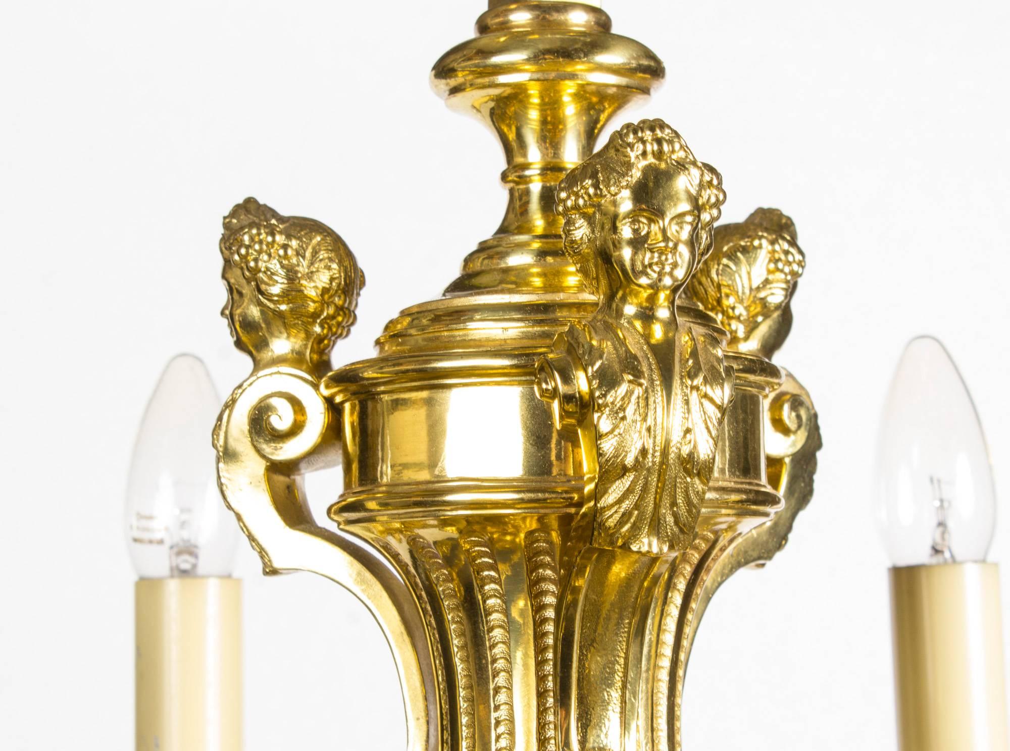 Il s'agit d'un lustre français très décoratif de style Louis XIV à douze branches en bronze doré, datant d'environ 1900.

Partant d'une colonne centrale, la partie supérieure est ornée de trois cariatides féminines entrecoupées de feuillages et de