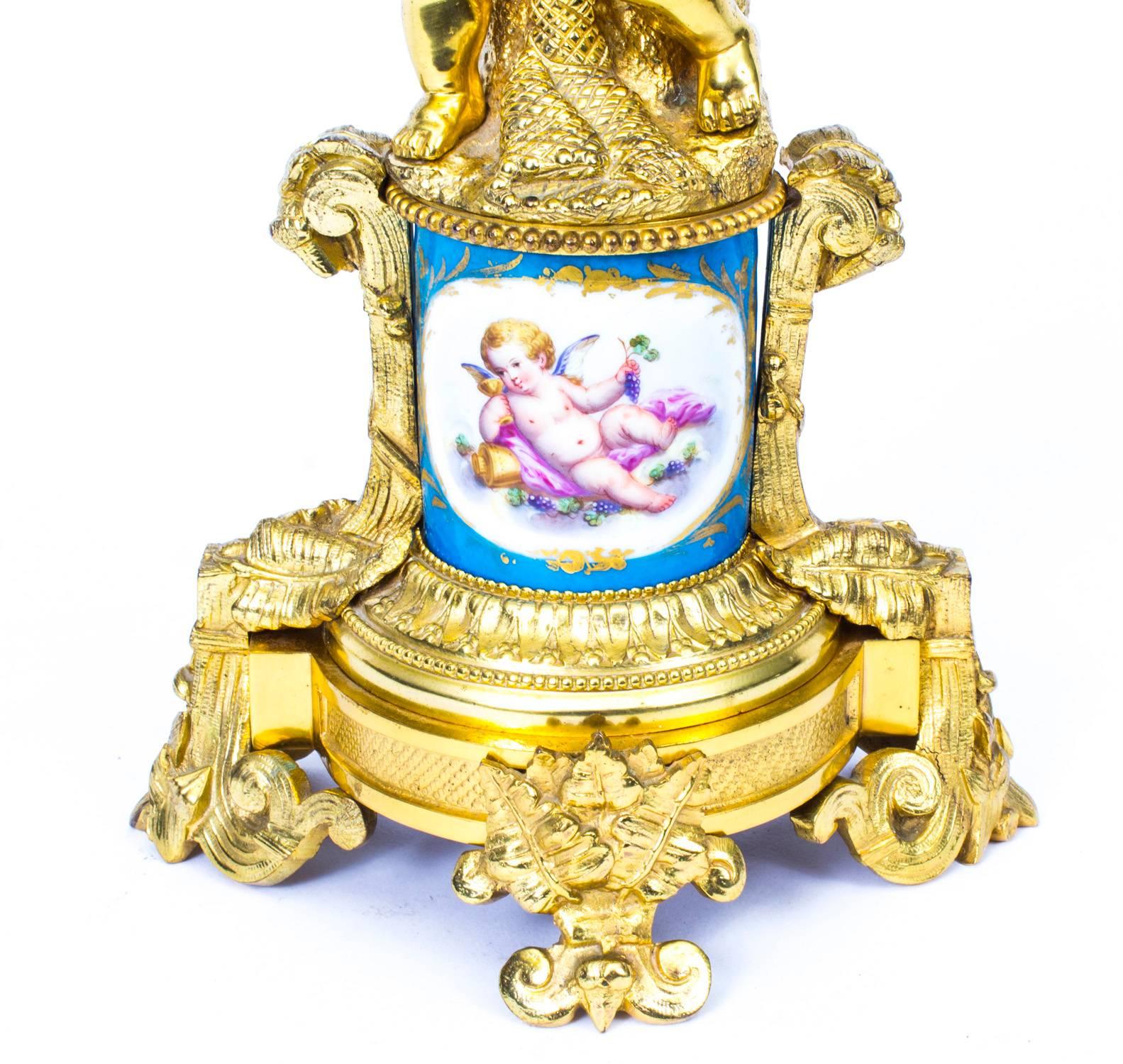 A fine quality French Sèvres Porcelain and ormolu electric table lamp, with central soft paste porcelain hand-painted socle support depicting a cherub on a celeste blue ground, ending on an ornate ormolu circular base, with spreading scroll feet,