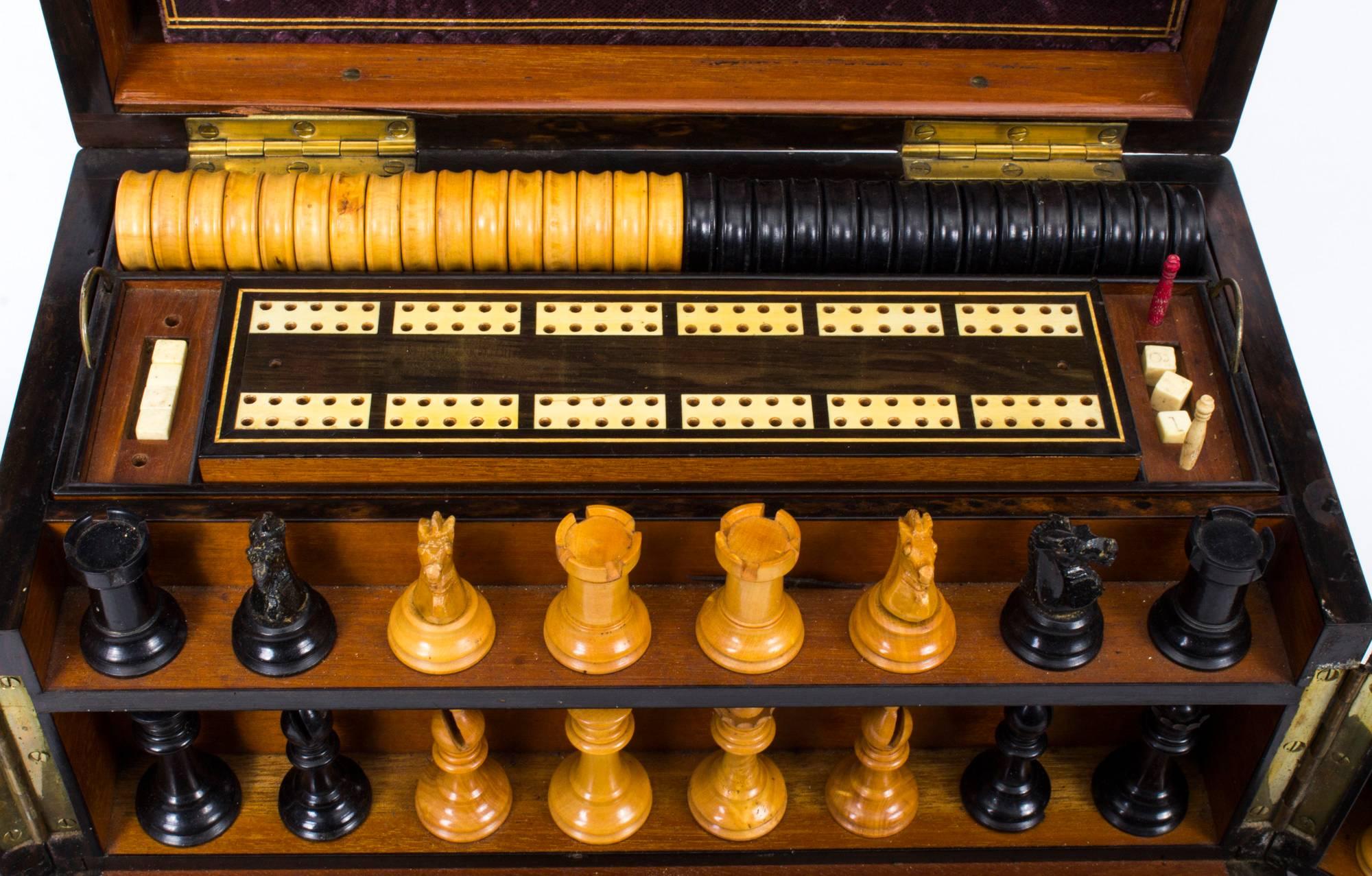 This is a wonderful antique Victorian coromandel games compendium, circa 1860 in date.

The hinged lid reveals fitted compartments, the interior with two lift-out trays, fitted with boxwood and ebony draft pieces, a cribbage board, bone dominoes,