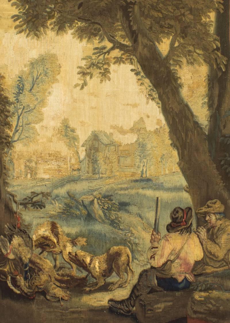 A superb French Aubusson tapestry panel, depicting a pair of huntsmen with their dogs and game birds in a wooded landscape, circa 1800 in date.

It is housed in it's richly carved giltwood frame which is decorated with a floral reef and a carved