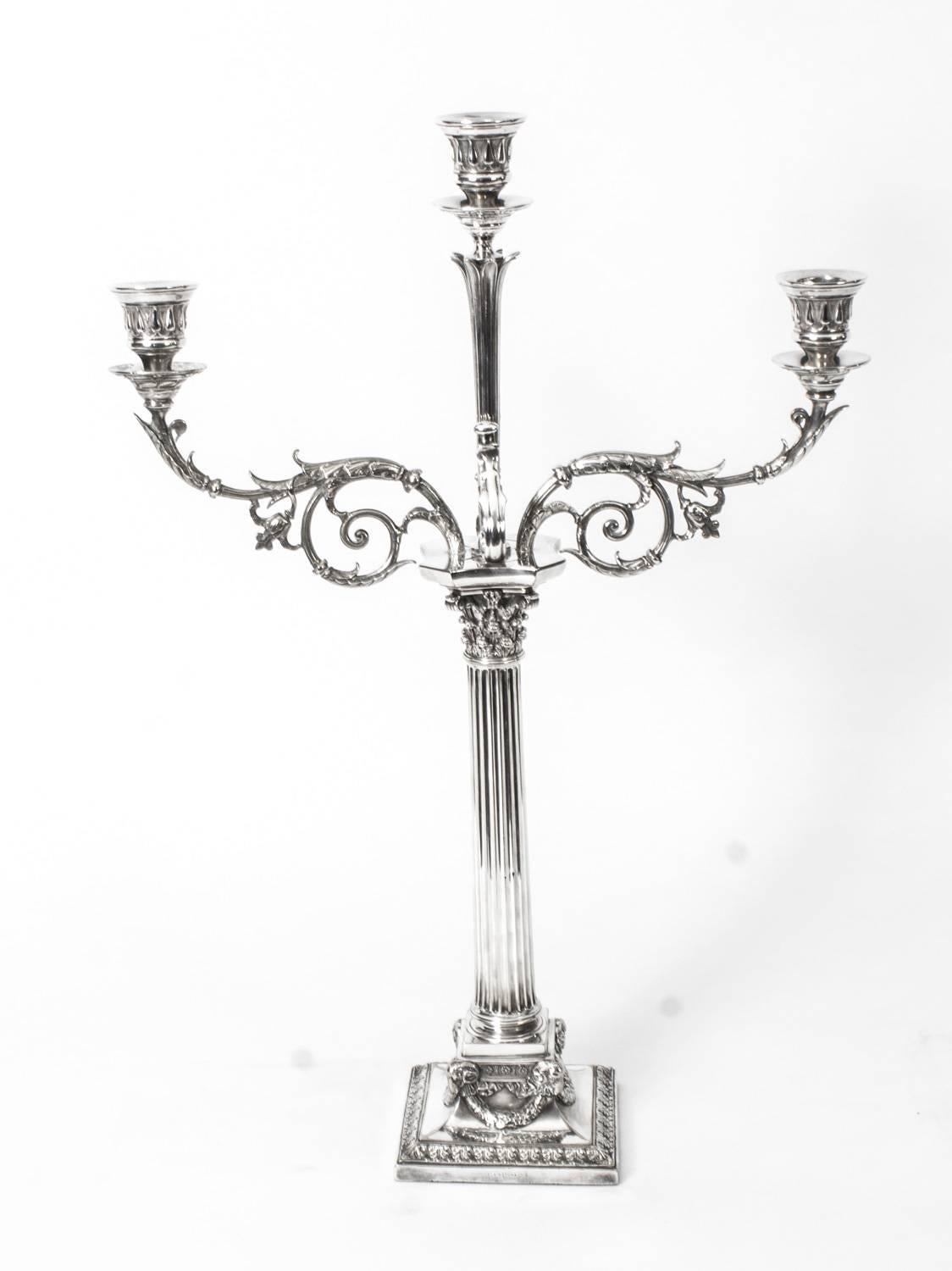 This is a stunning pair of antique Victorian silver plated, three light, two-branch table candelabra, circa 1865 in date, and each bearing the makers mark of the renowned English silversmiths Elkington & Co.

The candelabra each feature a Corinthian
