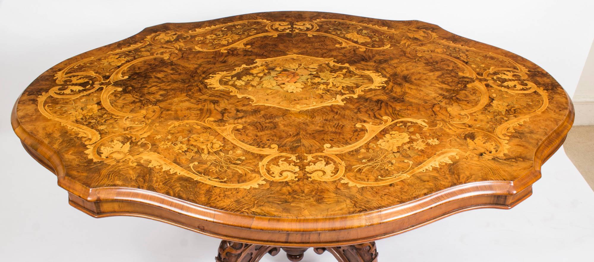 This is a superb antique Victorian burr walnut and marquetry loo table, circa 1860 in date.

The tabletop is shaped oval in form and features wonderful butterflied burr walnut with superb floral marquetry decoration. The base has been skillfully