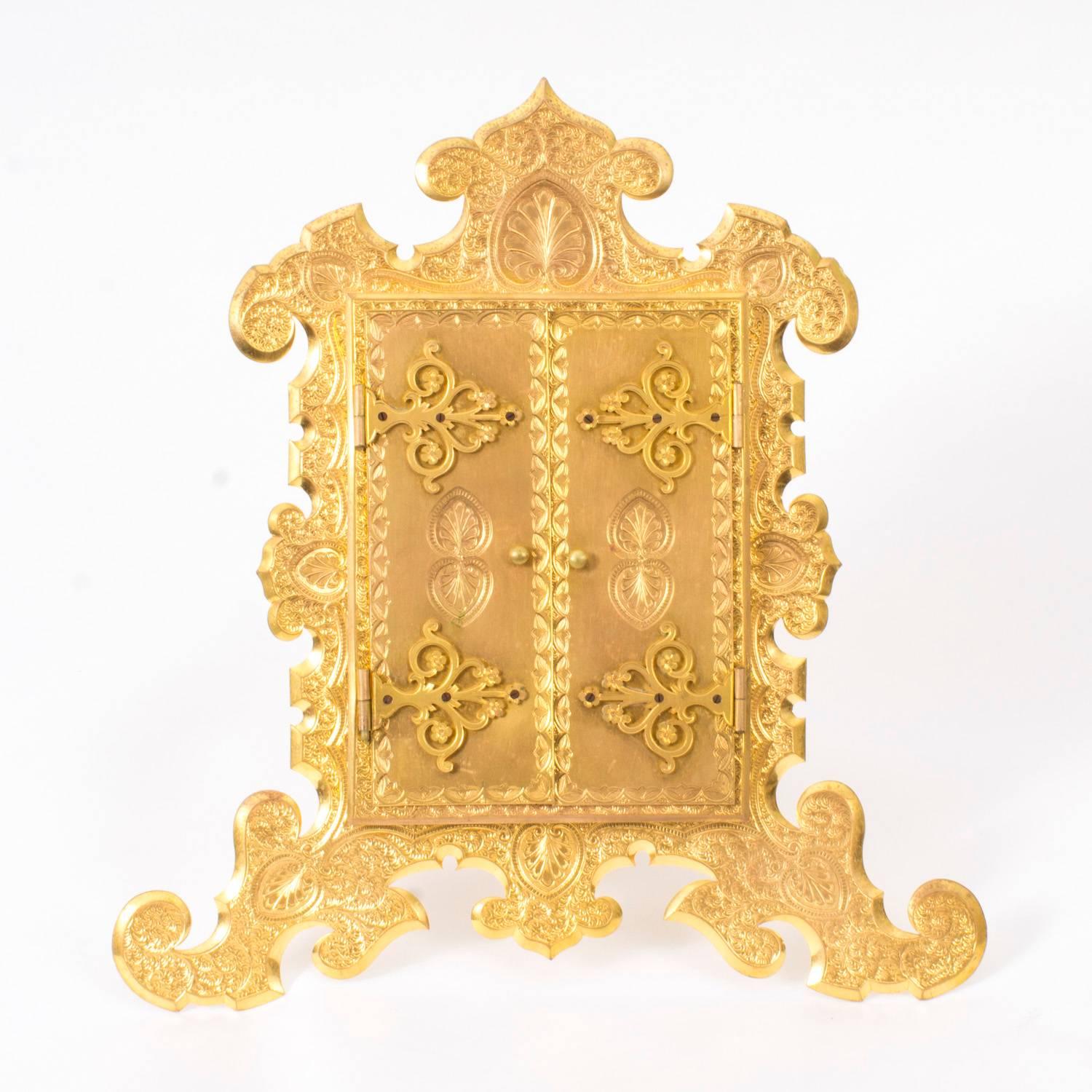 This is a lovely antique English Victorian gilt bronze picture frame, circa 1870 in date. 

The shaped frame features highly detailed engraved decoration with twin doors which open to reveal a rectangular recess for your photo. The back is