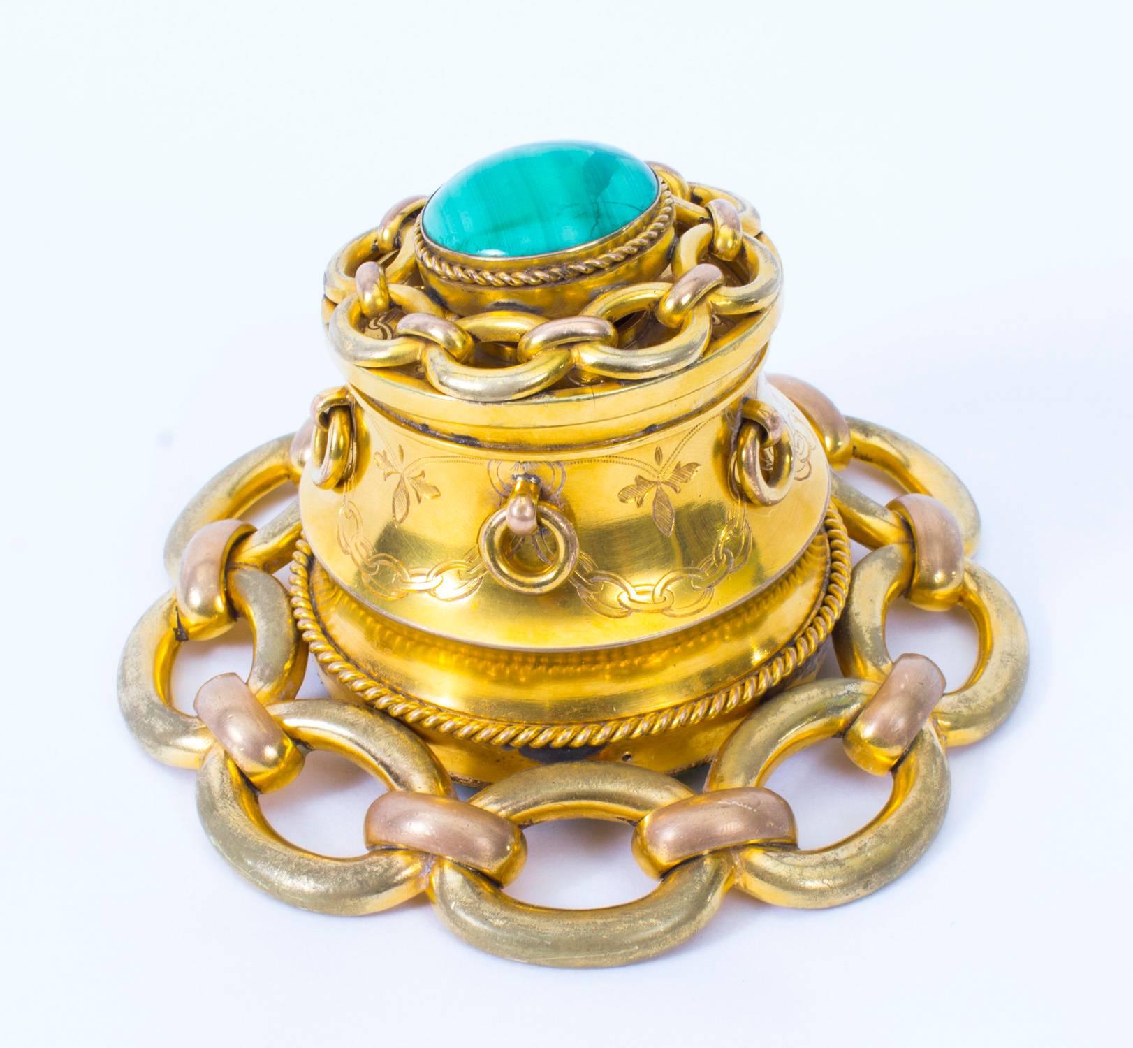 This is a wonderful antique Victorian ormolu and malachite mounted inkwell, circa 1870 in date.

The ormolu inkwell has a decorative inset turquoise cabochon gemstone with a chain link border, above a chain link base. There is no mistaking the