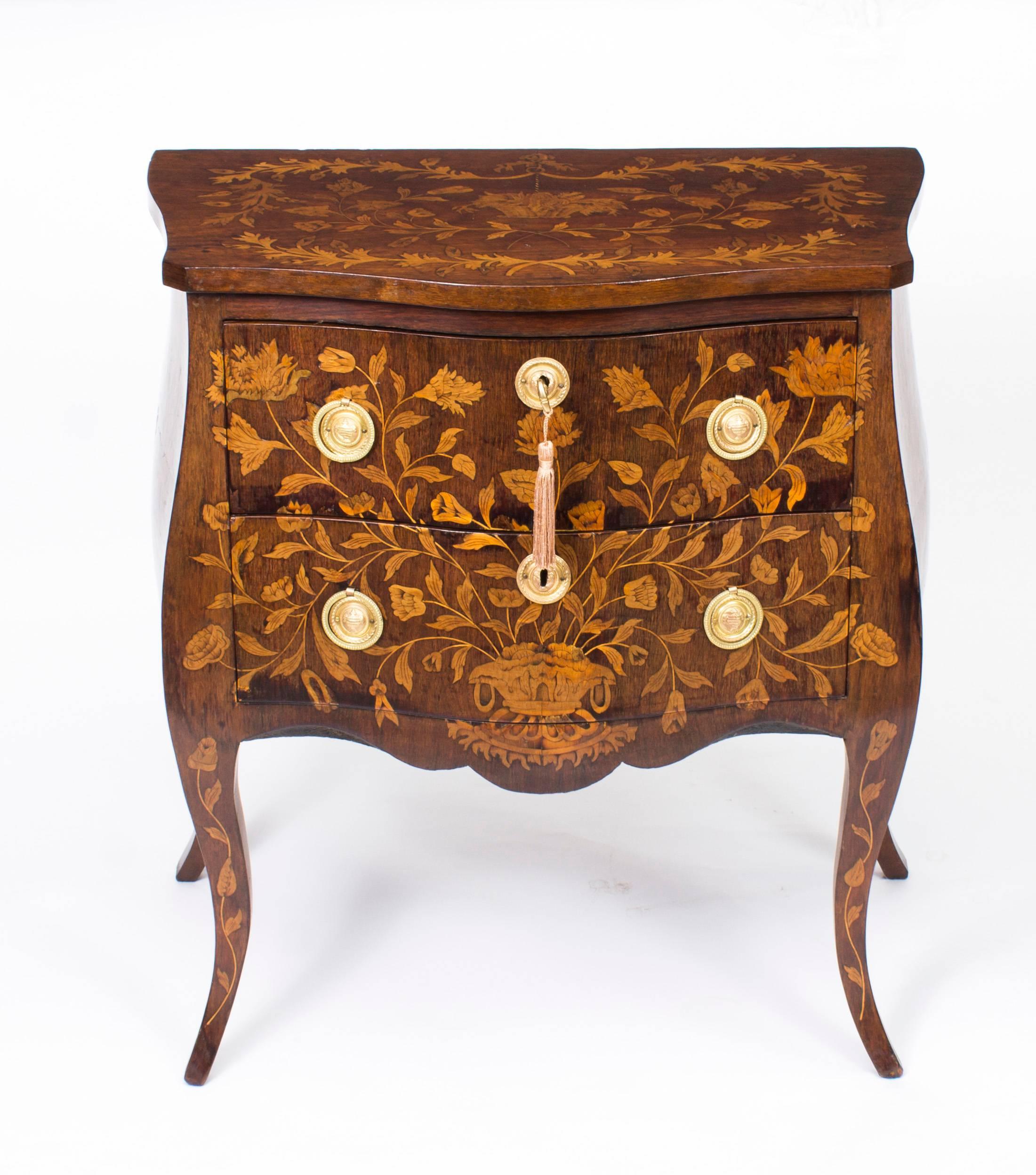 This is a stunning pair of antique Dutch marquetry bombe' bedside chests of drawers, circa 1790 in date.

The two drawer chests have been accomplished in walnut with exquisite hand-cut boxwood and fruitwood floral marquetry decoration typical of