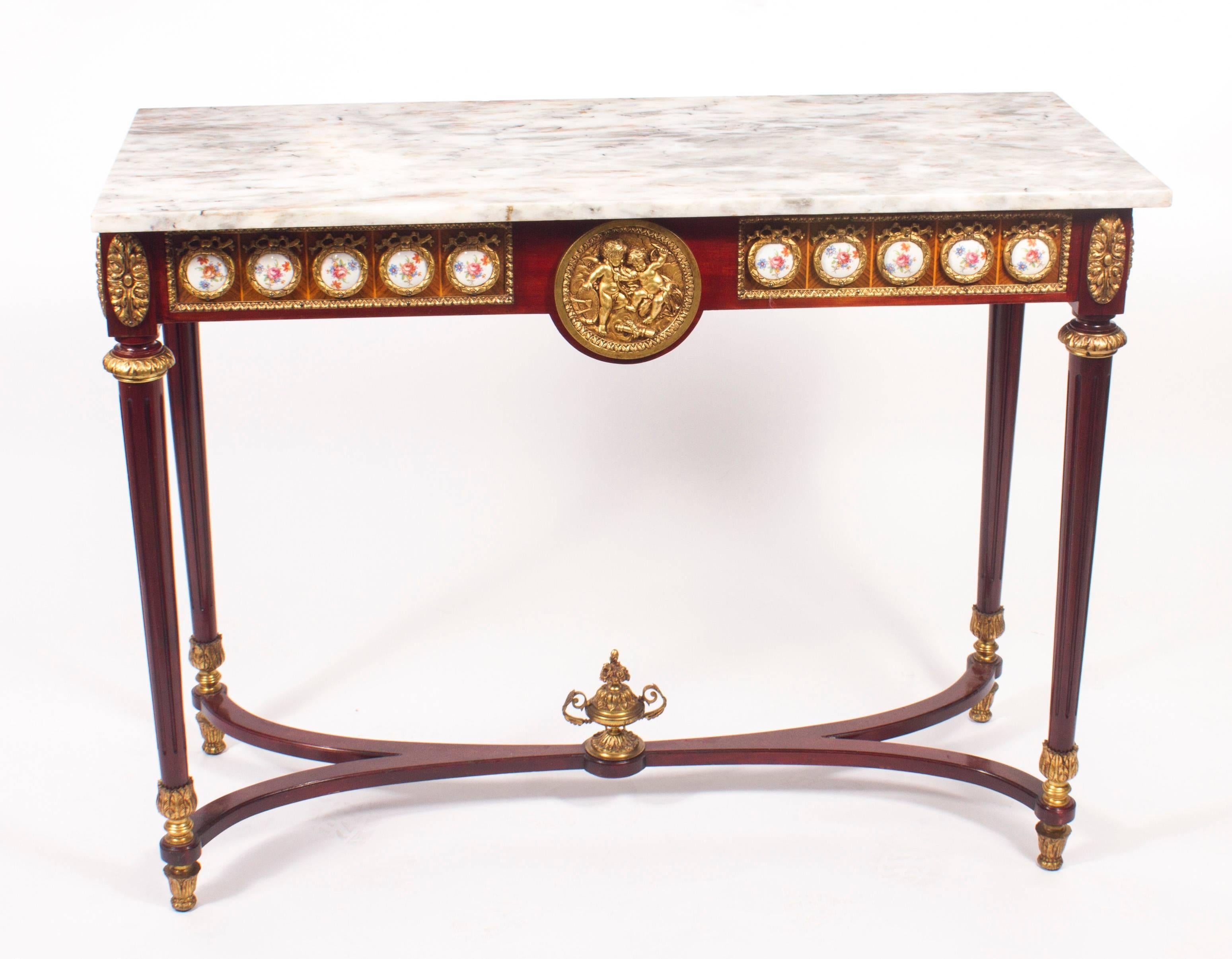 This is an elegant French Louis Revival console table dating from the 1970s.

This magnificent piece is crafted from mahogany and features eighteen floral painted Sèvres style oval porcelain plaques and superb ormolu mounts with a central circular
