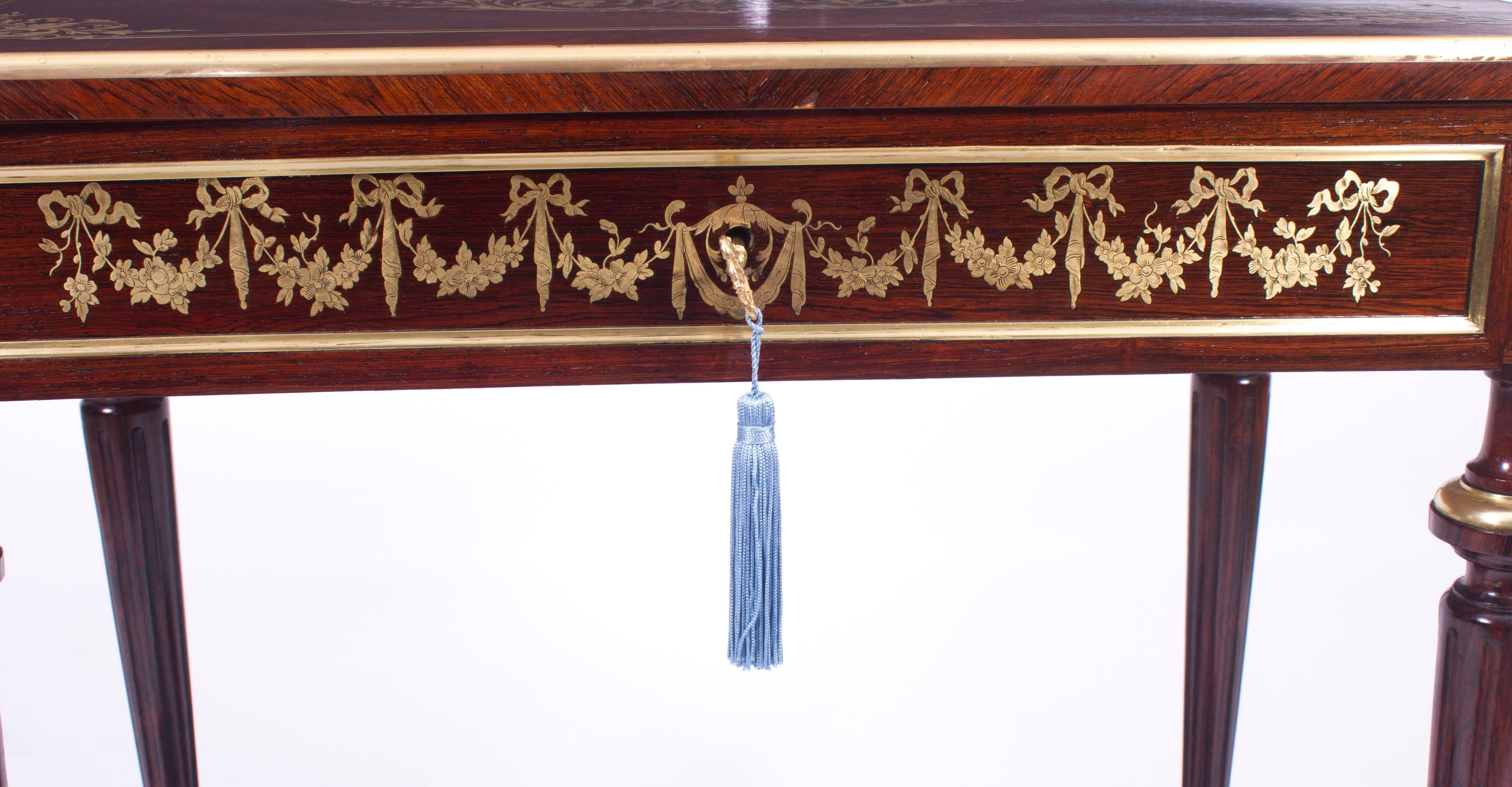 This is a beautiful antique French goncalo alves wood and cut brass inlaid rectangular occasional table, circa 1850 in date.

The lift up lid features superb cut brass marquetry inlaid decoration consisting of a scrolling cartouche classical urn