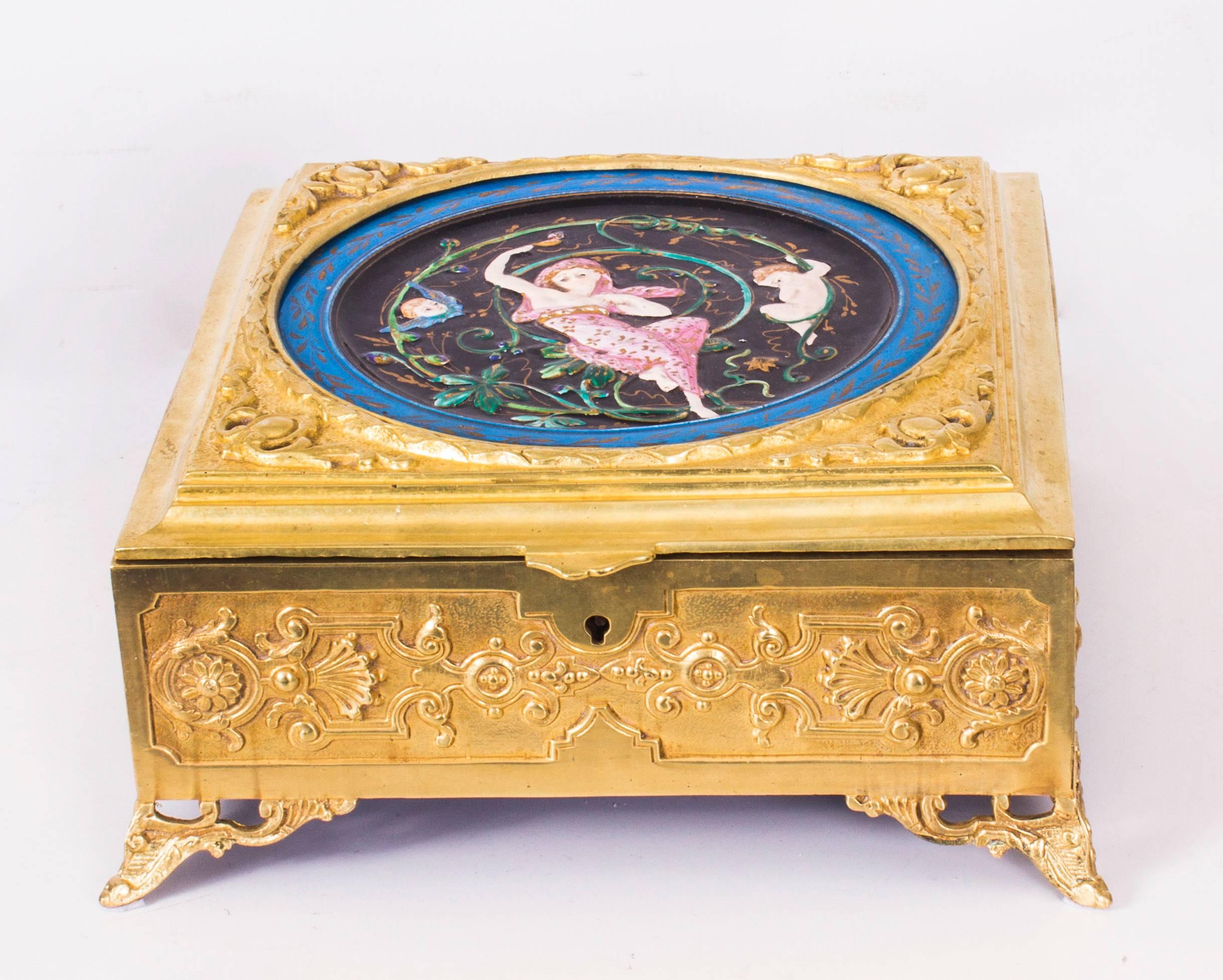 This is an absolutely fabulous antique English Art Nouveau ormolu and Minton porcelain casket, circa 1890 in date.

The top is inset with a superb hand painted rectangular porcelain plaque with cherubs and a maiden decorated in relief. The ormolu