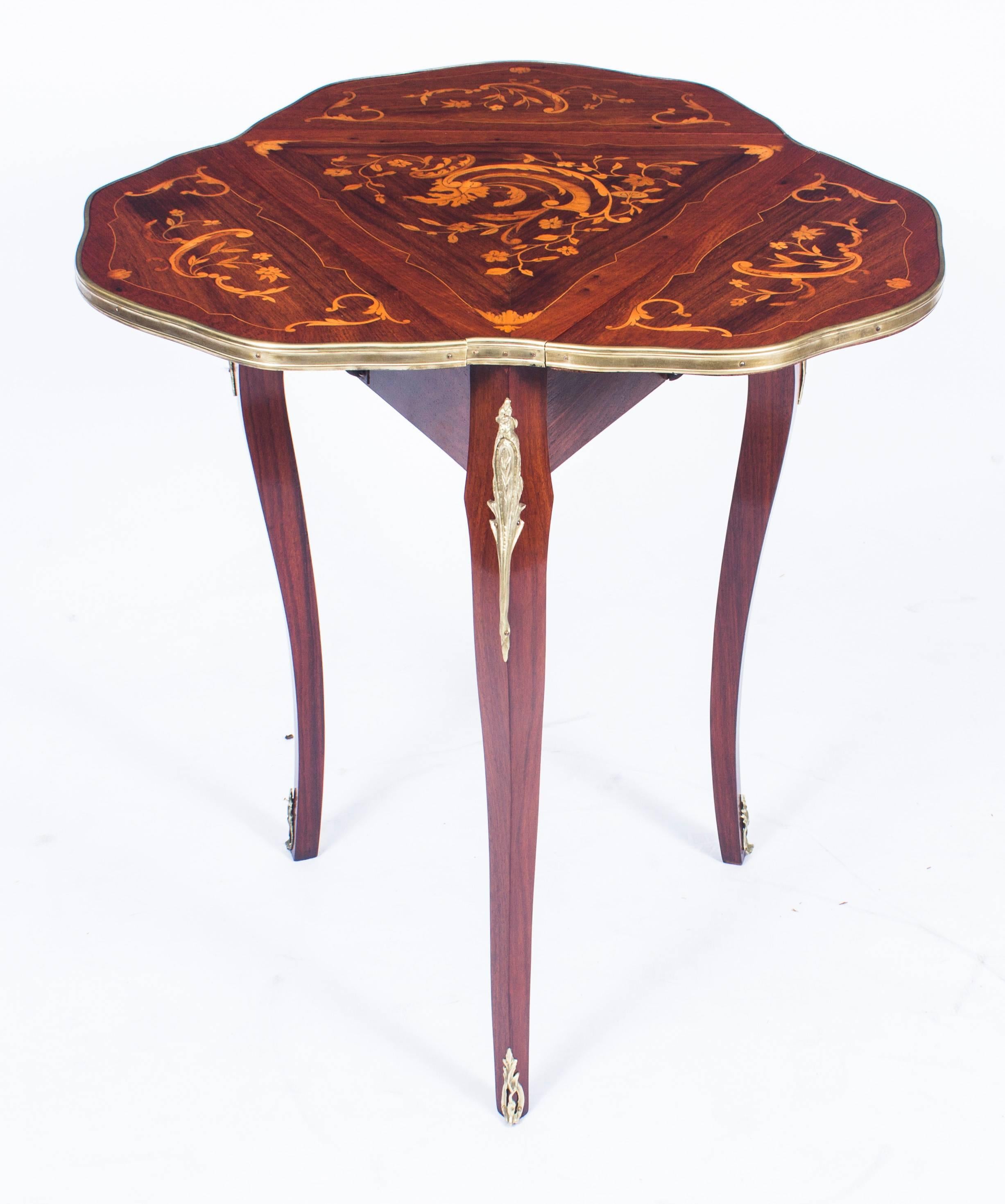 This is a beautiful antique Louis Revival ormolu mounted mahogany and marquetry triform occasional table, circa 1870 in date.

It has a shaped top and fall leaves inlaid with the most beautiful marquetry decoration of flowering stems and leafy