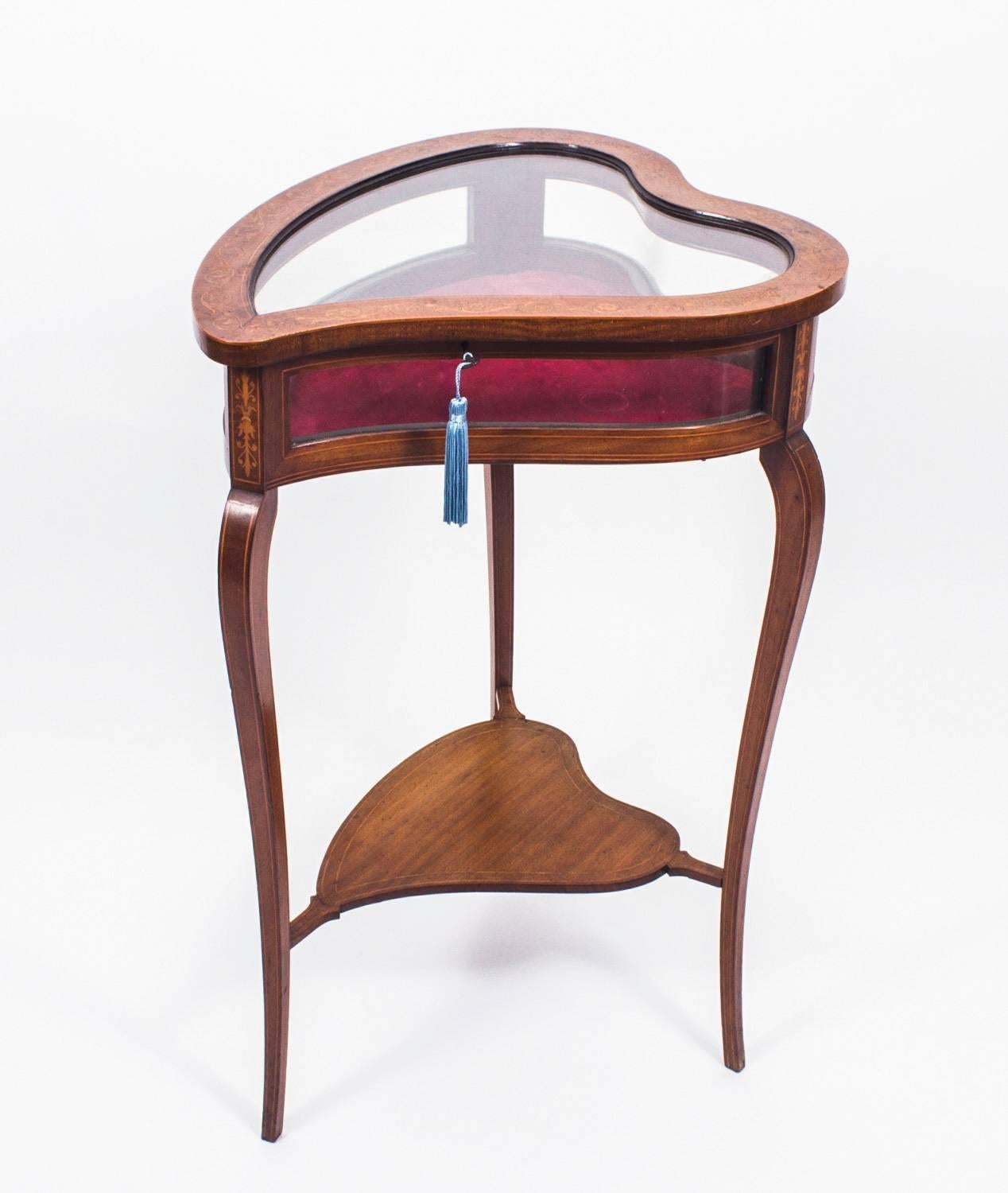 This is a beautiful antique Edwardian inlaid mahogany and heart shaped display table in the Louis XV style, circa 1890 in date.

It has a glazed lift top with glazed sides and it's original burgundy velvet lining. The glass top is framed with