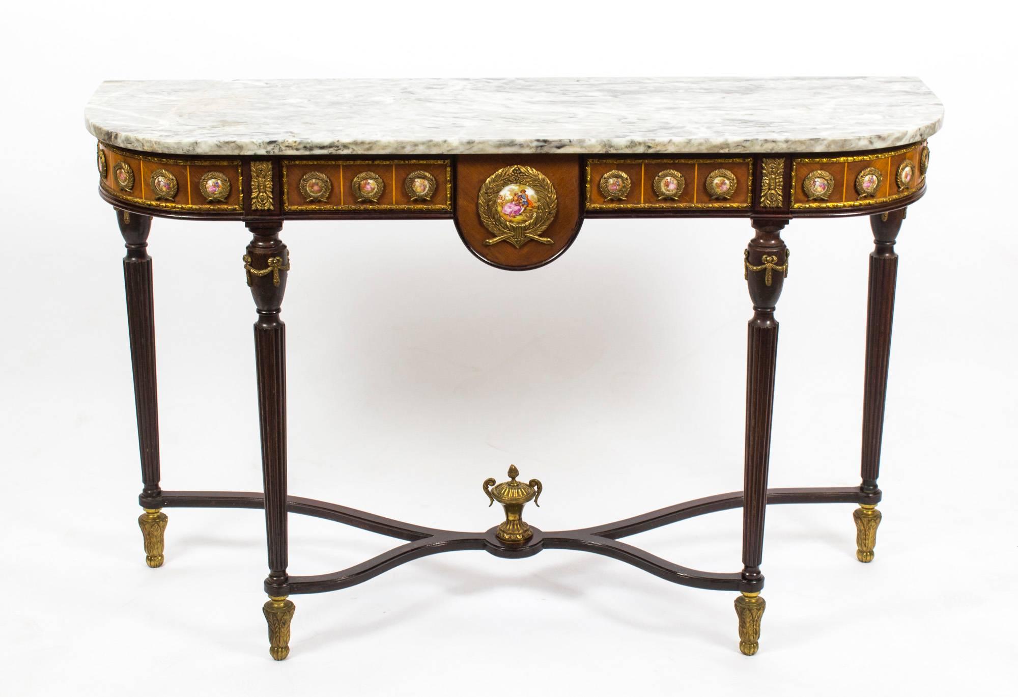 This is an elegant French Louis Revival console table dating from the 1970s.

This magnificent piece is crafted from walnut and features a plethora of Sevres style porcelain plaques, superb ormolu mounts and a beautiful 'Gris St Anne' marble