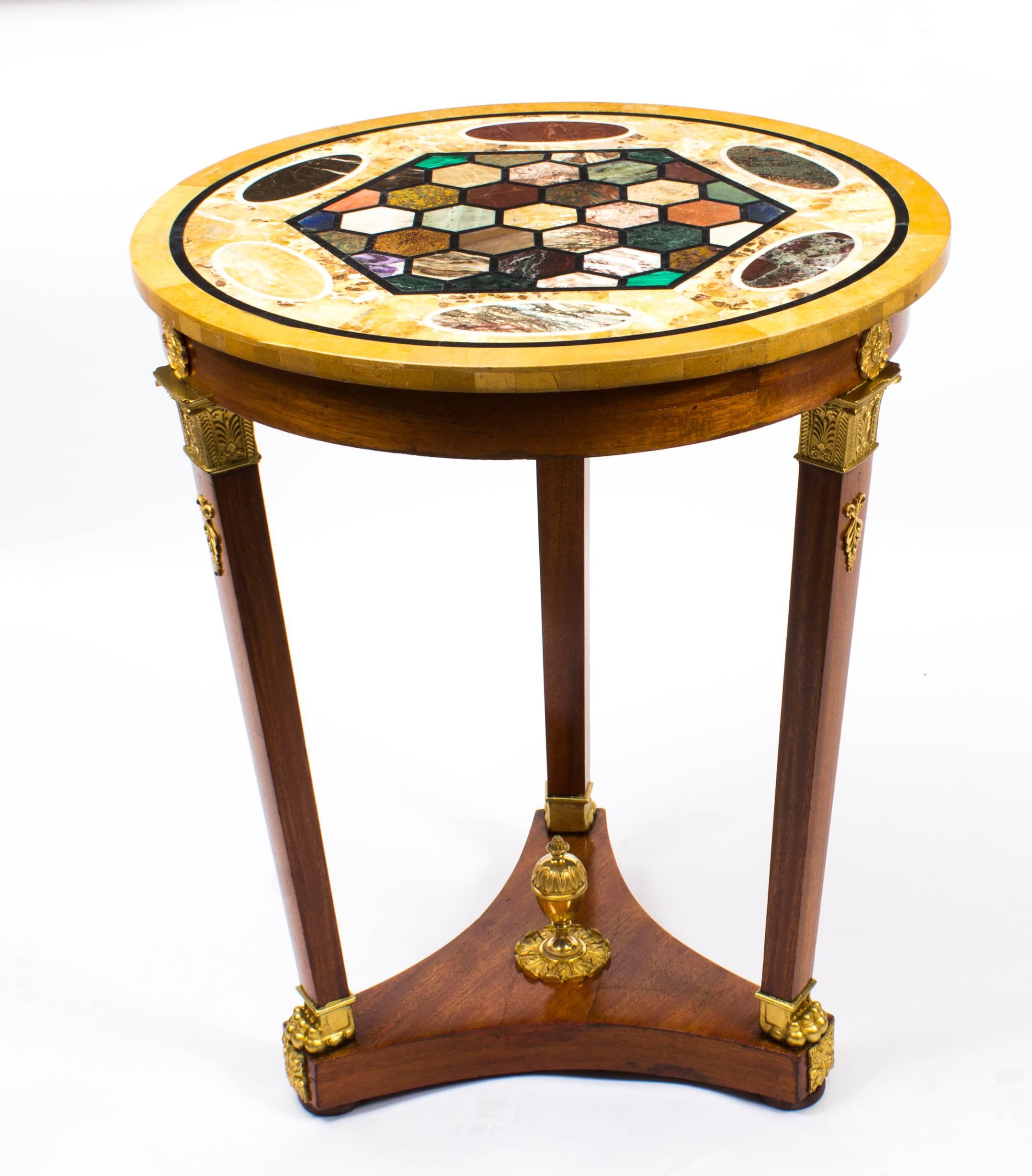This is a beautiful antique early 20th century French Empire style circular marble top Bouillotte table decorated with gilt bronze mounts.

It is masterfully crafted in blonde mahogany and raised on an elegant triform base centred by a gilt bronze