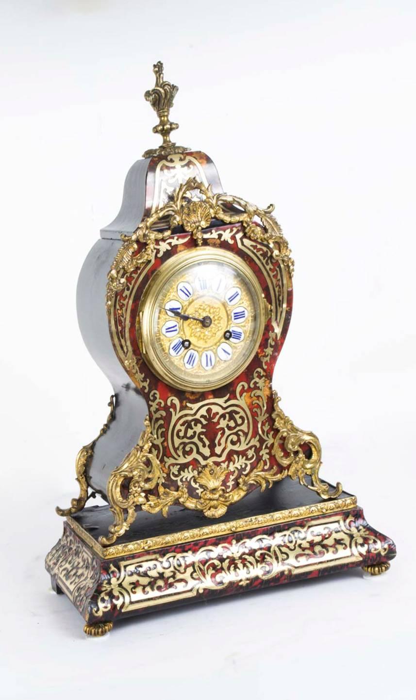 This is a beautiful antique French Boulle mantel clock on stand, circa 1870 in date.
This clock has a fabulous brass and enamel dial and a bell striking movement. The case and stand is of beautiful red Boulle, with cut brass inlaid decoration, and