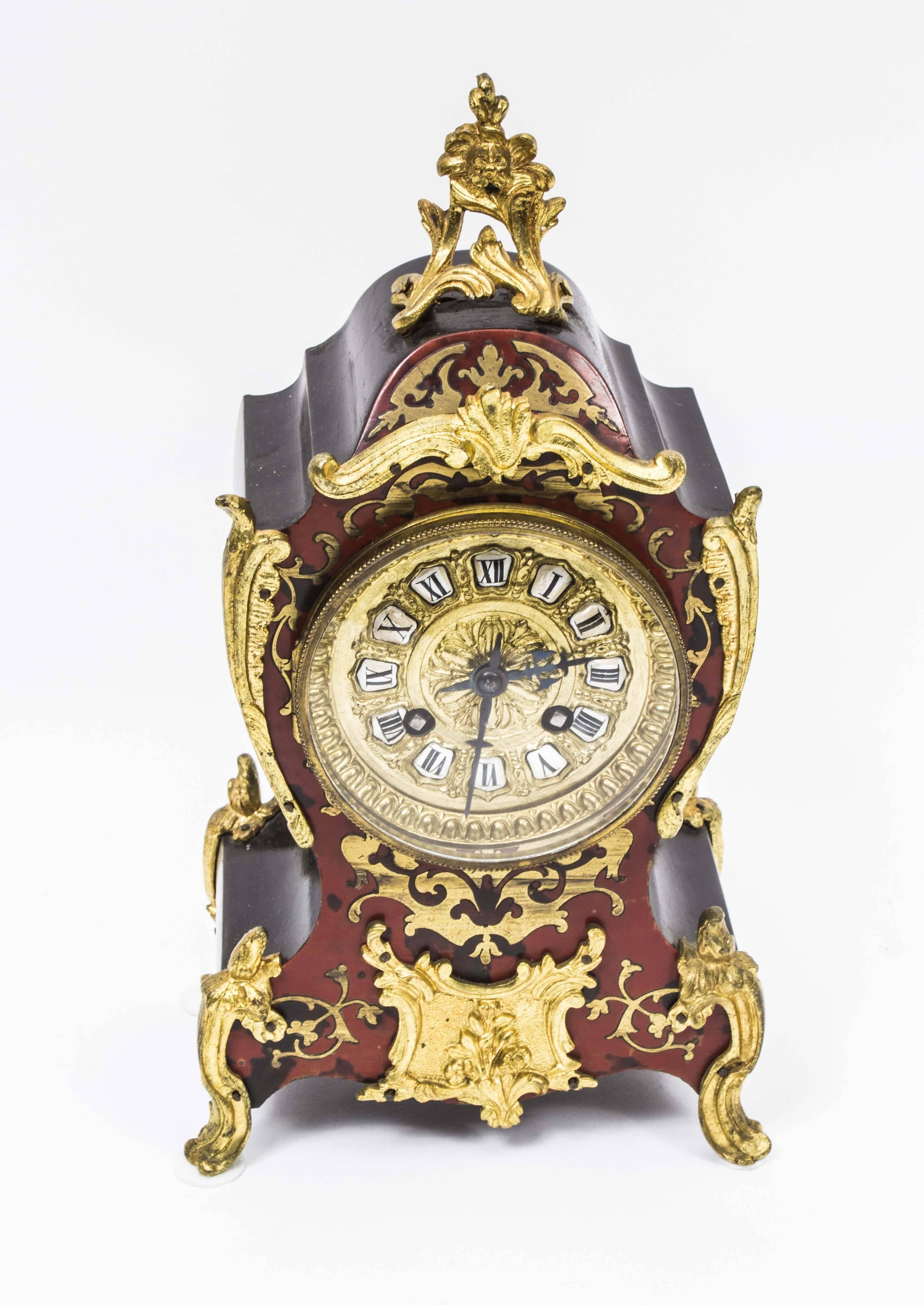 This is a beautiful antique French Boulle and cut brass ebonized mantel clock of cartouche shape, circa 1875 in date.
The nine cm dial is inscribed with Roman numerals upon enamel reserves and it has an eight day movement striking on a gong,