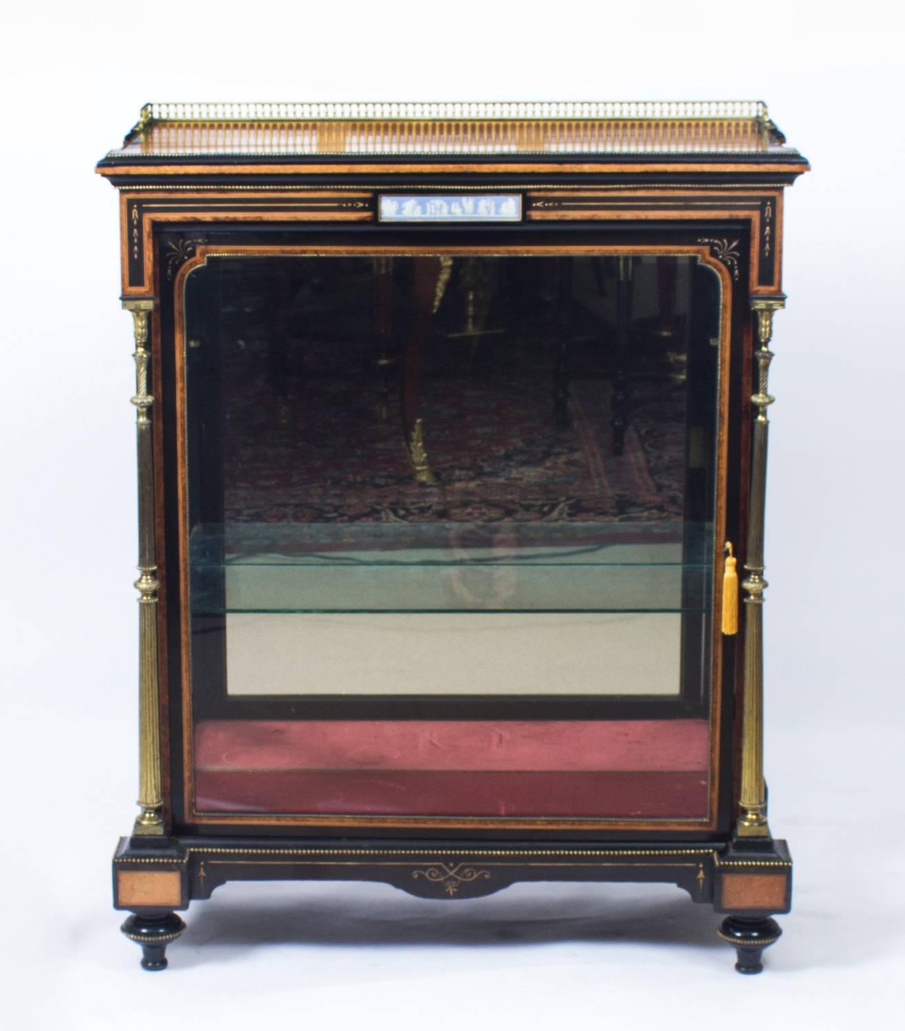 Il s'agit d'une belle armoire victorienne ancienne en amboine et ébène, datant d'environ 1850.

Le plateau rectangulaire en amboine présente une élégante galerie en laiton au-dessus d'une frise incrustée d'une plaque en jaspe 