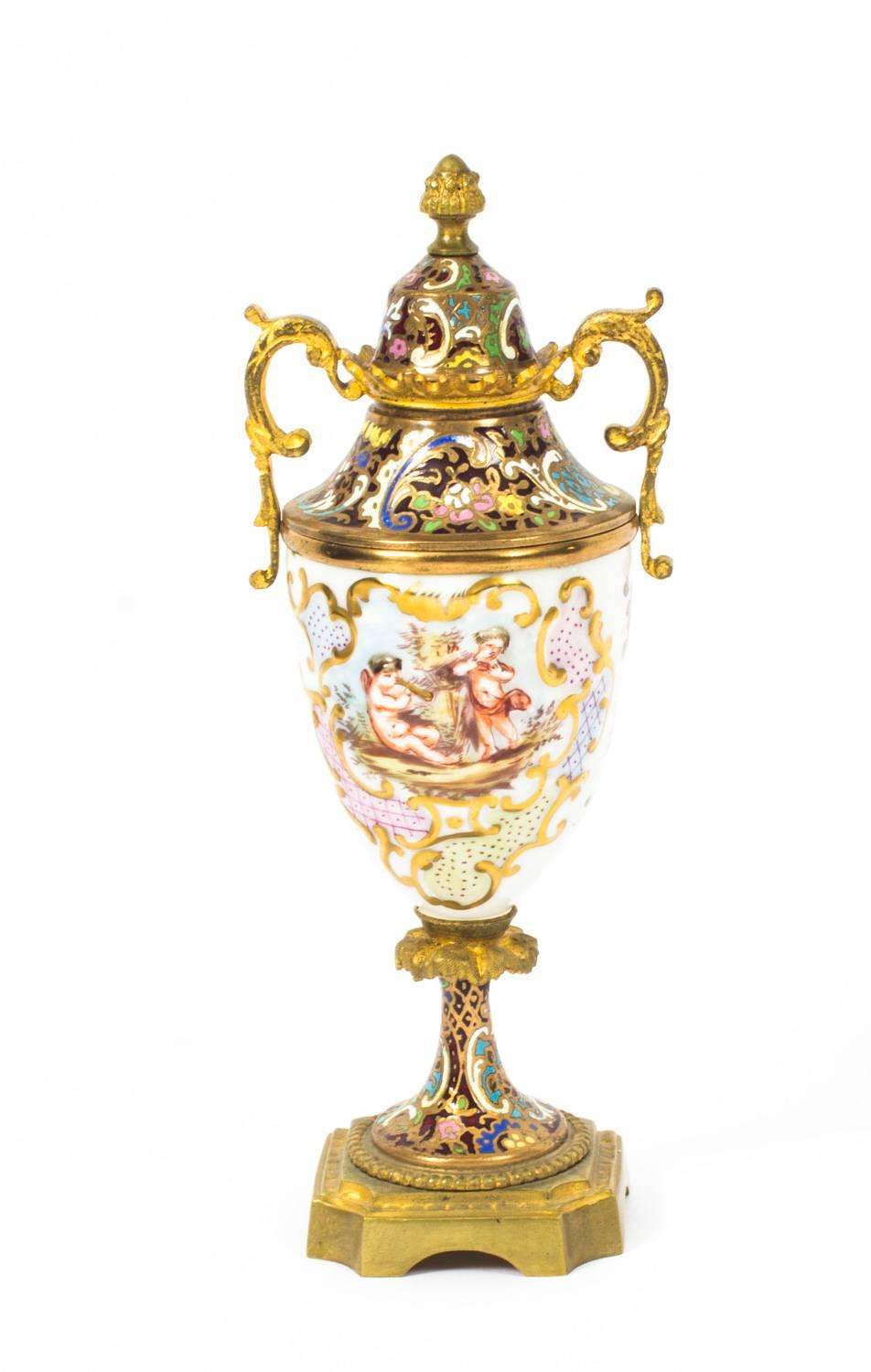 This is a beautiful antique pair of Italian Capodimonte porcelain lidded urns with French ormolu mounts and champleve enamel detailings, Circa 1880 in date.

They are superbly decorated in the Capodimonte manner with hand painted moulded and