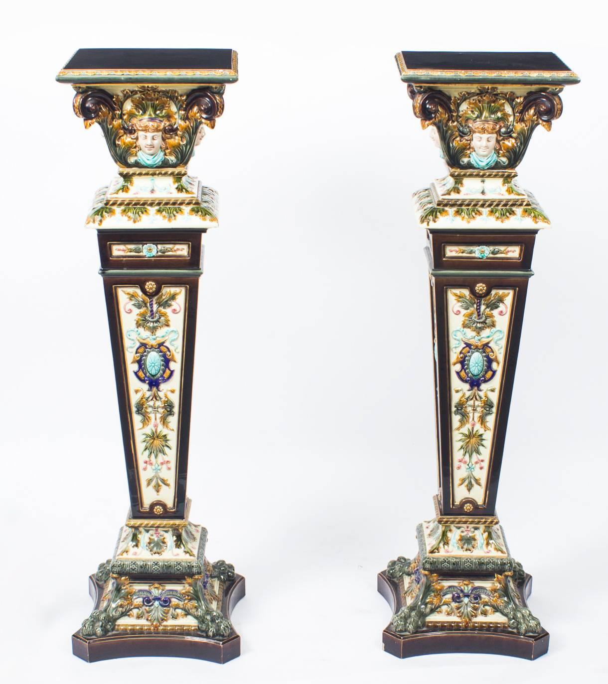 This is a gorgeous antique pair of Swedish Rorstrand majolica pedestals, late 19th century in date.

They feature richly colored decoration in green, blue, turquoise, pink and gold. The capitals are moulded with female masks with scrolls and sit