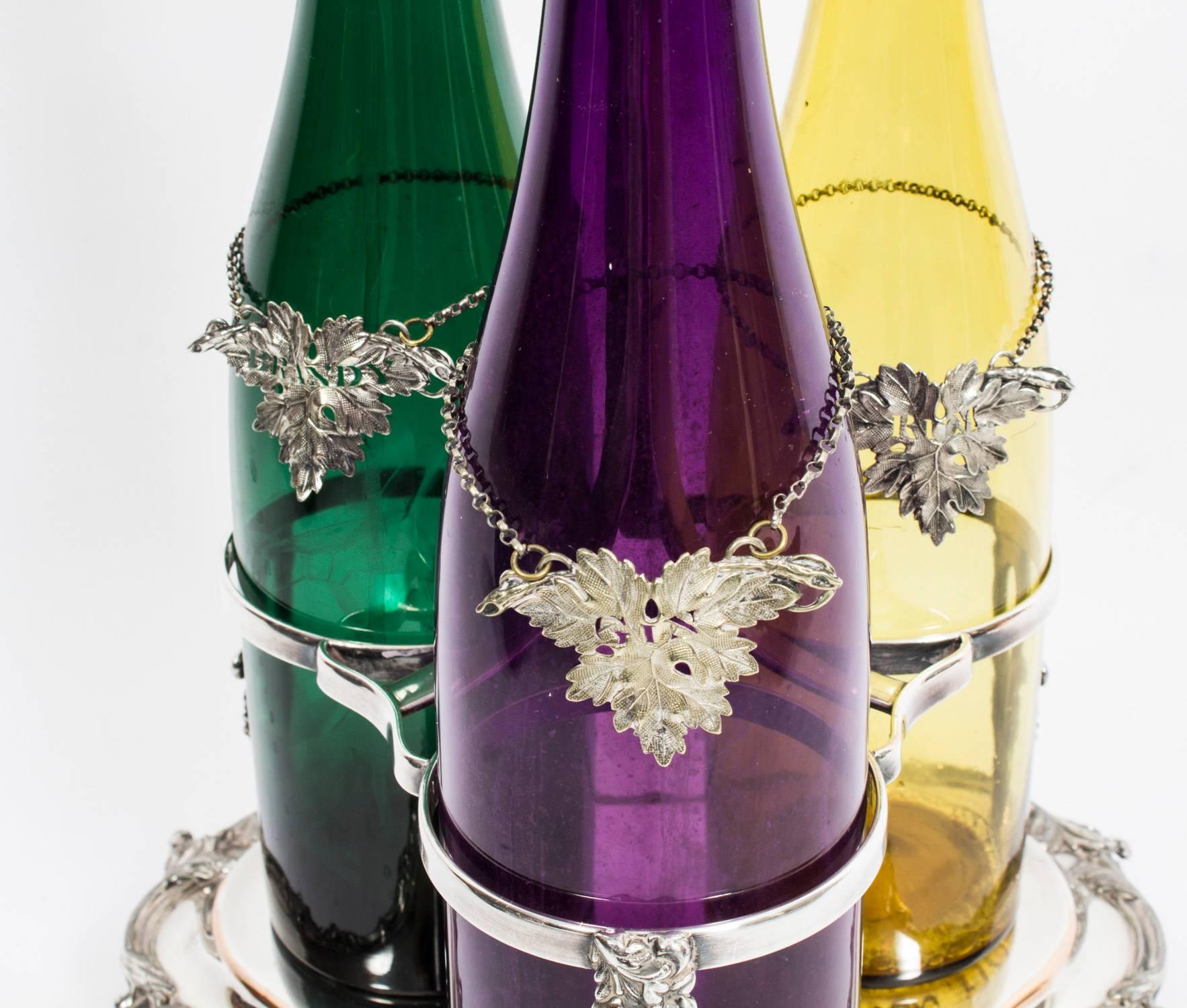 This is an attractive Old Sheffield silver plated  tantalus stand with three decanters with stoppers, in the classic English style and circa 1840 in date.

The silver plated decanter stand has a central spade handle and waved scroll and form
