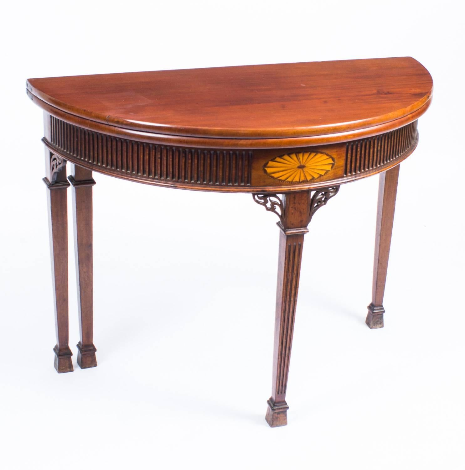 This is a beautiful antique Edwardian inlaid mahogany demilune card table, late 19th century in date.

The card table is of mahogany with a moulded top above a fluted frieze centred with a beautiful neoclassical inlaid satinwood shell and is
