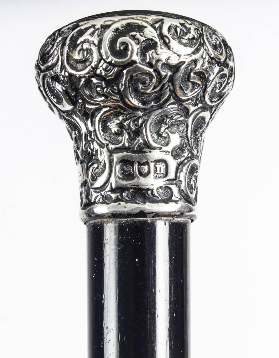 This is a beautiful antique English Edwardian silver mounted conductor's baton that has hallmarks for London, 1908.

The fully ebonized and sterling silver mounted tapered cylindrical baton features wonderful scrolling decoration to the silver