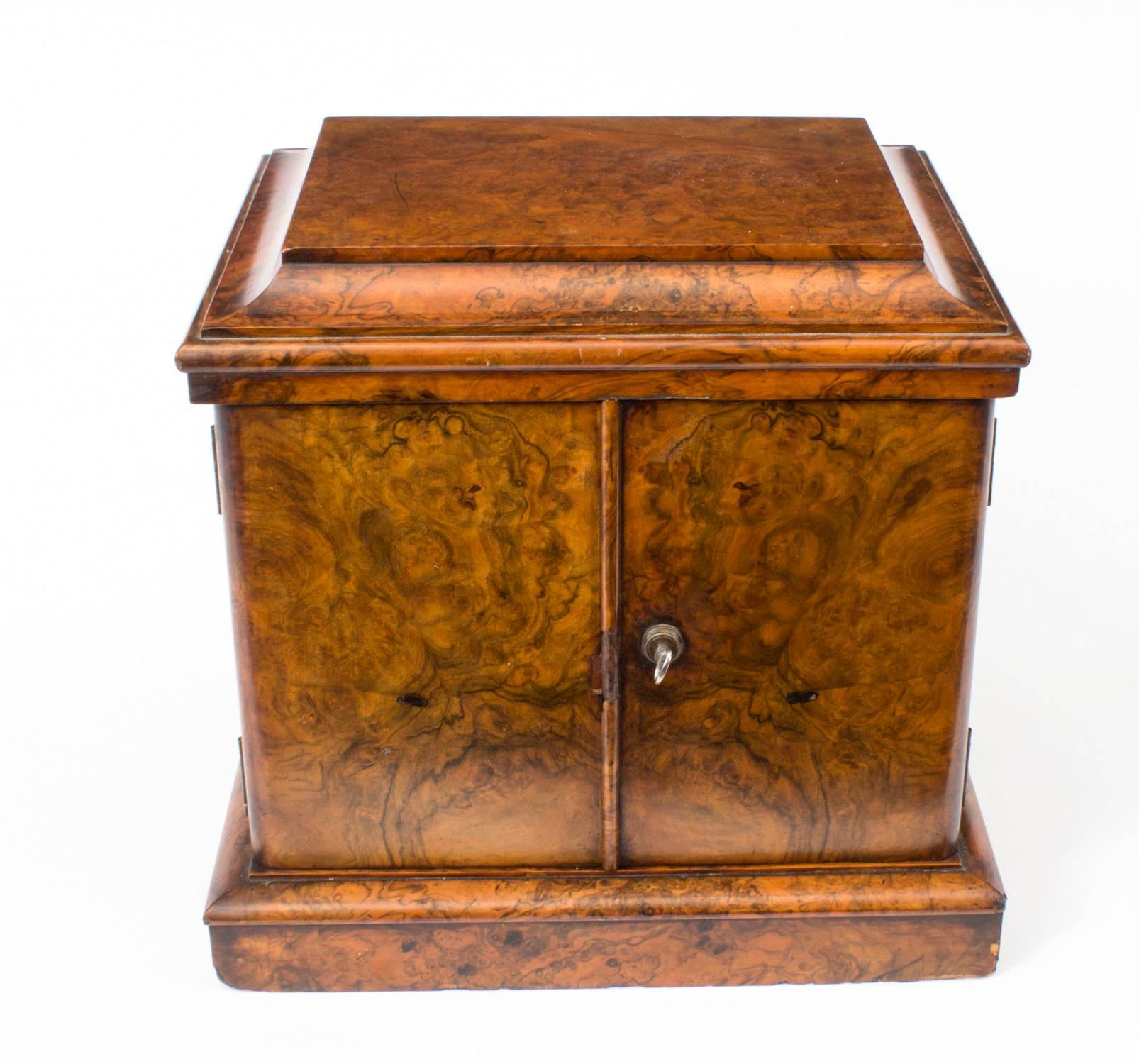 This is a stylish antique Victorian burr walnut table top cigar box, circa 1870 un date.

Th oversailing cadd top above a pair of doors centred by a baton that open to reveal two full width drawers fitted with flush brass 