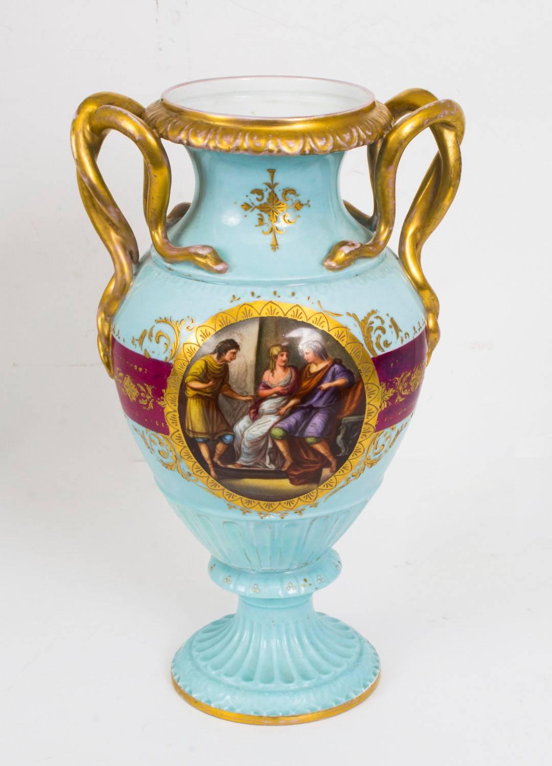 This is a wonderful pair of antique Vienna porcelain two handled classical vases with serpent handles, circa 1880 in date.

Each with hand painted figural panels on a bleu celeste and purple Royale ground, with gilded decoration and bearing the