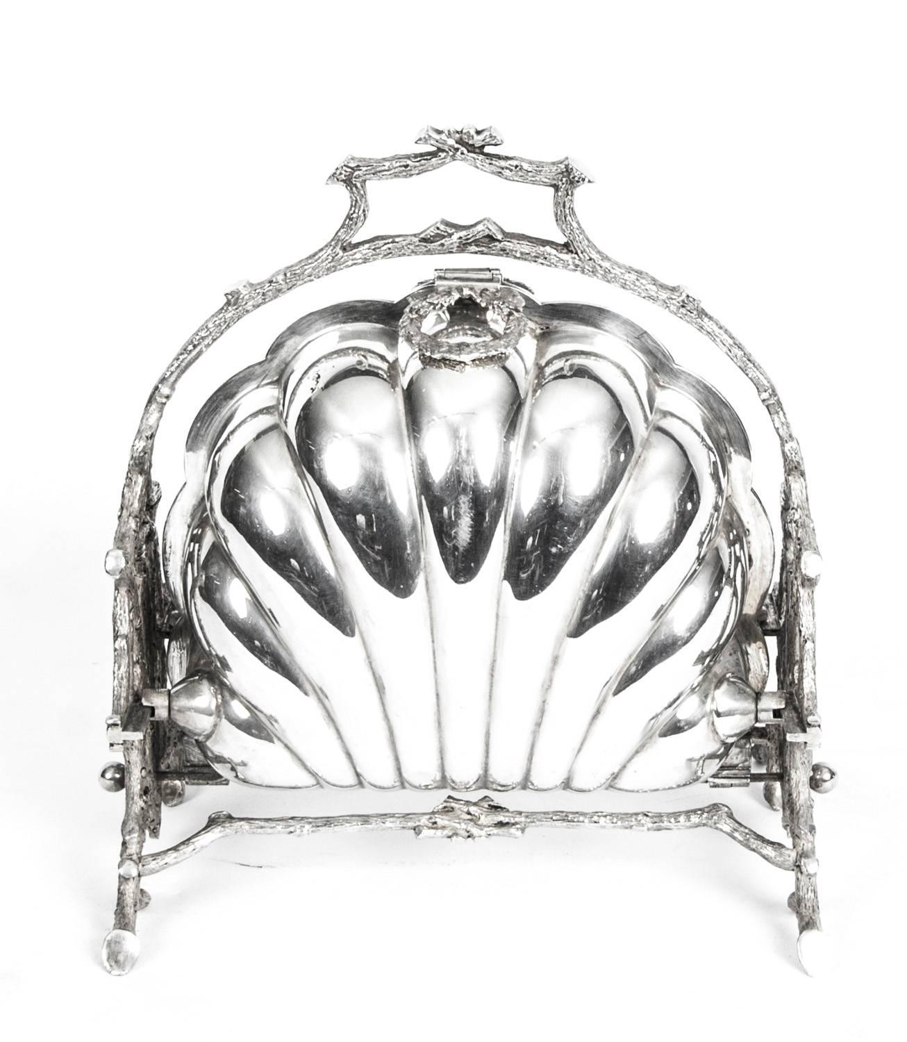 This is a beautiful Antique Victorian silver plated folding biscuit box, having a plain shell-style body sitting in a cast frame, and with original interior hand-pierced dividers circa 1880 in date.

The opening mechanism is as intricate as the