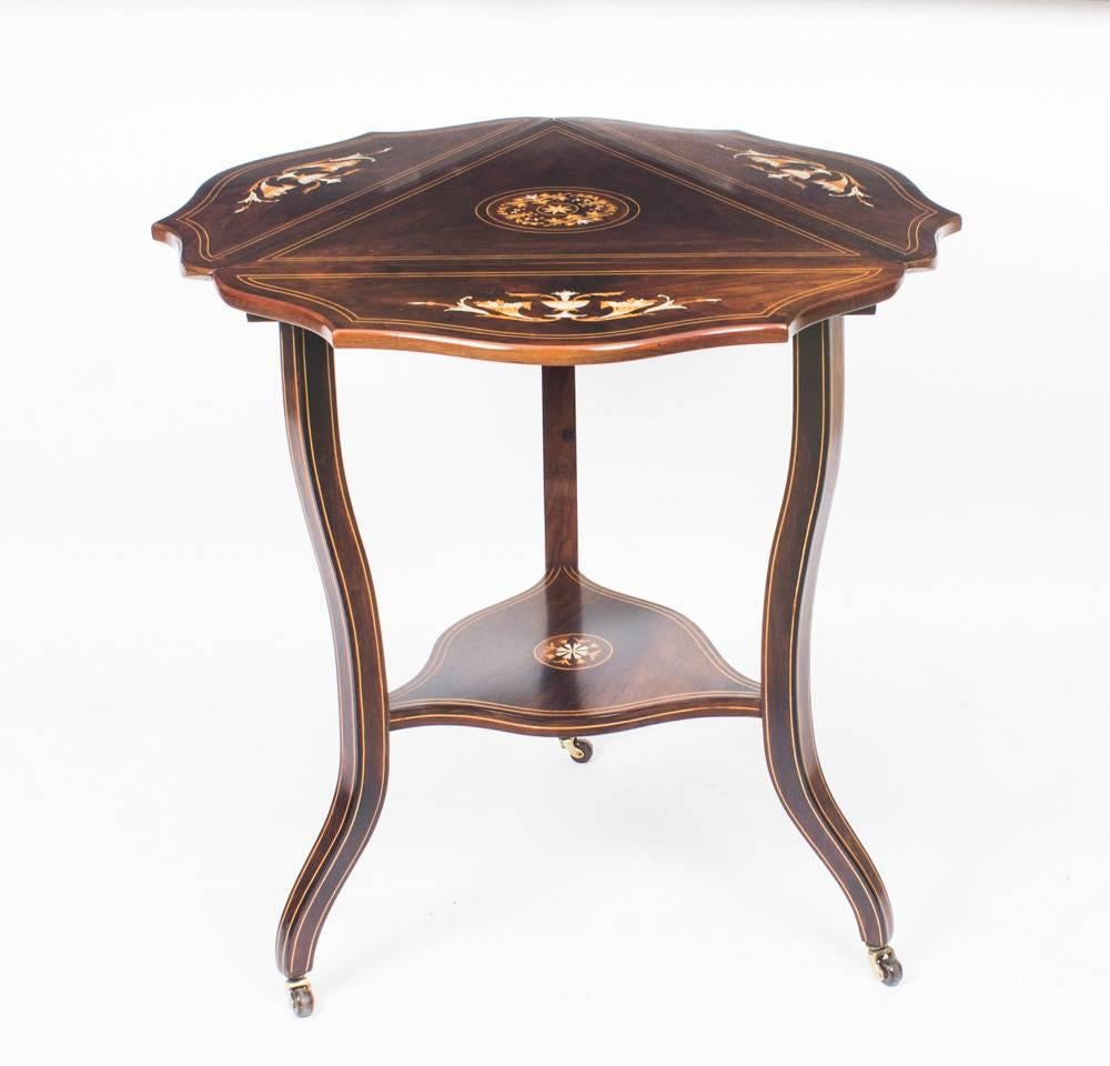 This is a unique stylish antique Edwardian specimen woods inlaid triangular drop flap occasional table, circa 1900 in date.

The drop flaps can be raised to form a shaped circular top or lowered as required to suit the occasion, the superb kingwood