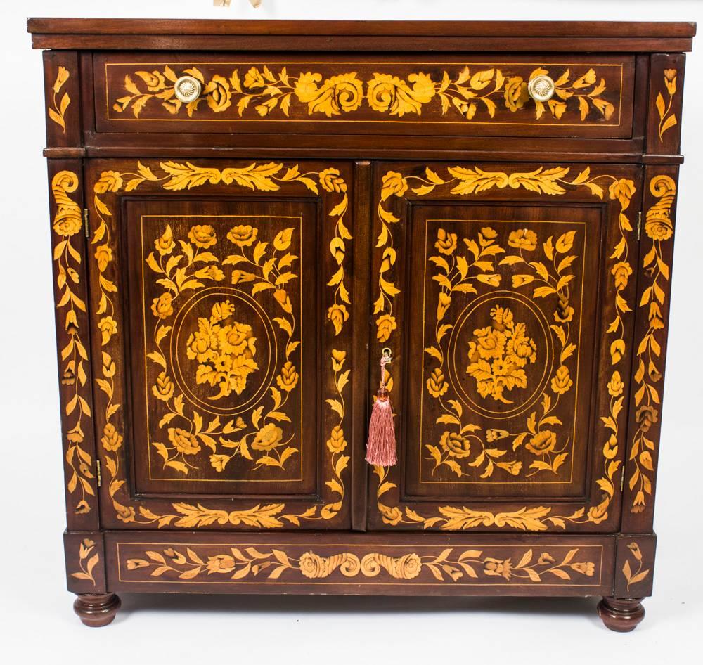 This is a stunning antique Dutch floral marquetry chiffonier circa 1780 in date.

Made from mahogany the chiffonier is inlaid with a beautiful marquetry decoration of ribbons urns garland and bouquets of flowers.

It has a useful full width drawer