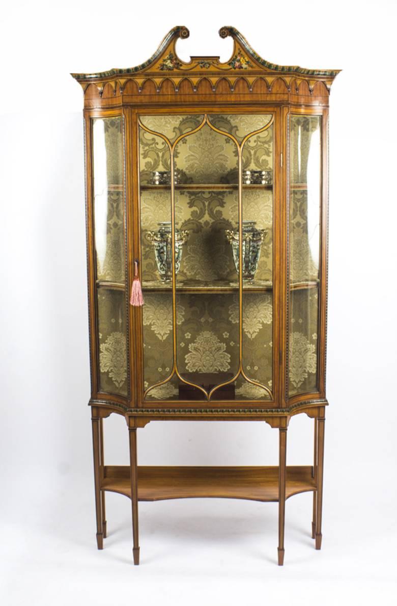 This is a magnificent antique English Edwardian satinwood display cabinet, circa 1880 in date.

The cabinet is of the very highest quality, made of satinwood with ebonised stringing and beautiful hand painted decoration in the manner of Angelica