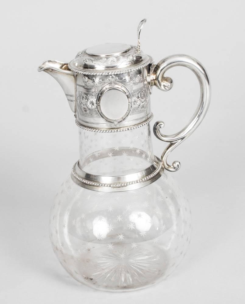 A superb antique Victorian sterling silver mounted and crystal claret jug, with hallmarks for Shefield 1864 and the makers mark of W & G Sissons.

The piece has a superbly engraved crystal body with a beautifully chased silver mounted handle and