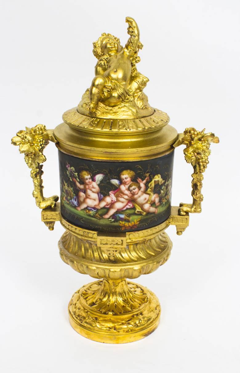 This is a stunning pair of French twin handle ormolu garniture lidded urns, with Sèvres hand painted porcelain, bearing the stamp of PH Mourey, circa 1870 in date.

The ormolu handles with grape vine decoration, the ormolu lids with seated cherubs