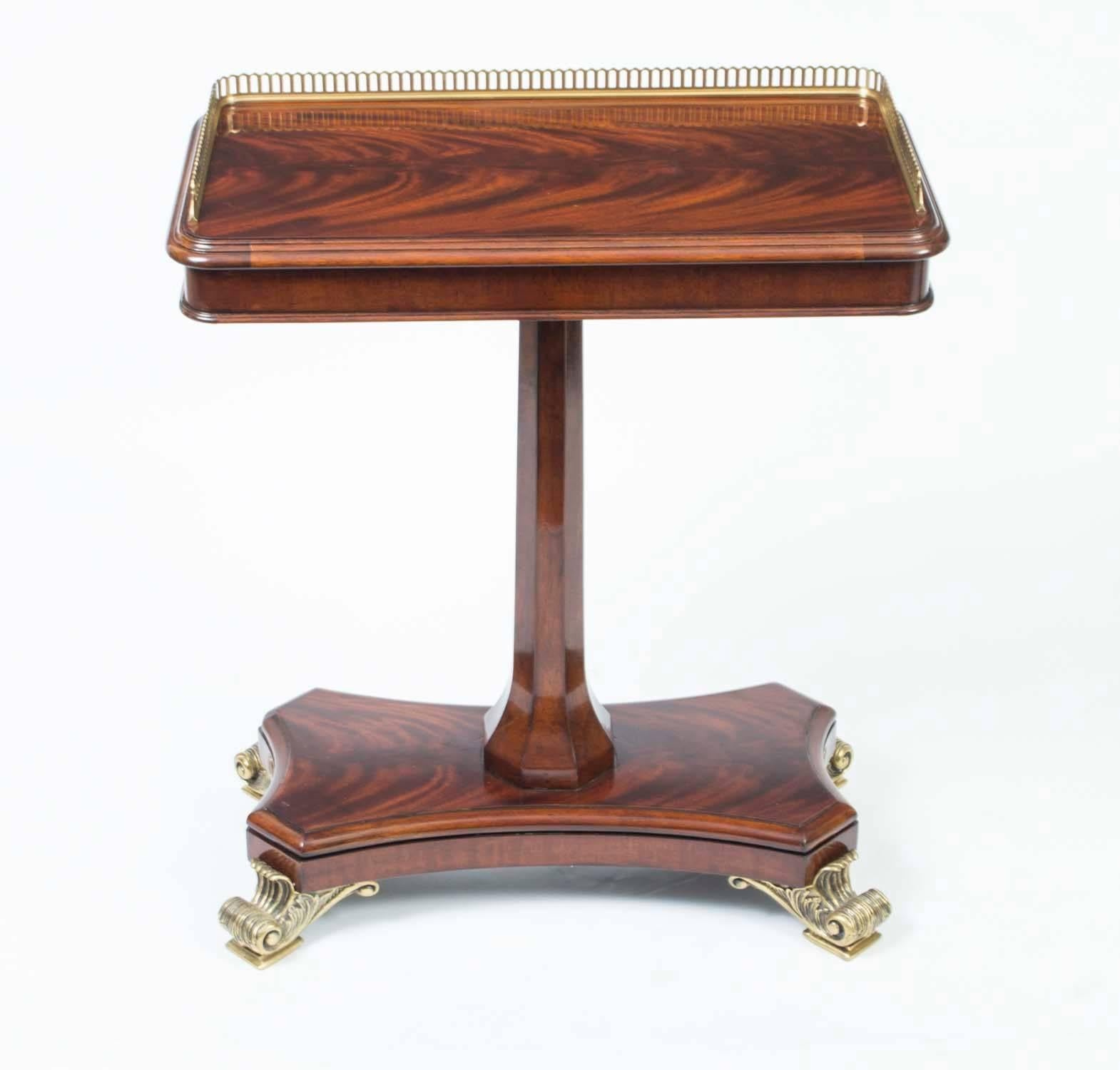 This is a handsome Regency style occasional table from the last quarter of the 20th century.

It has been masterfully created by Italian craftsmen in flame mahogany with a brass gallery and gorgeous ormolu feet.

Perfect at the end of a sofa as a