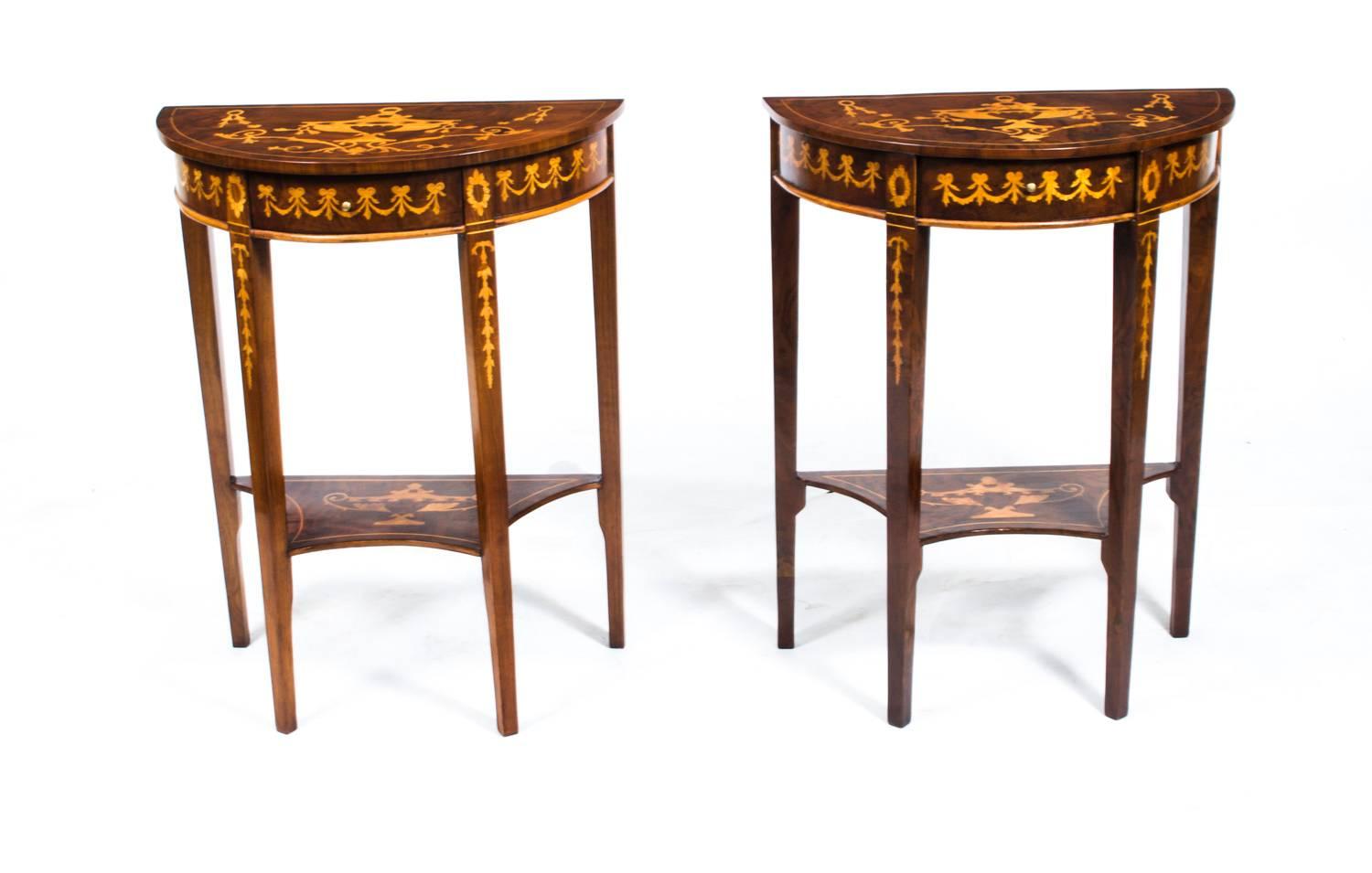 This is a stunning pair of vintage Sheraton style bur walnut half moon console tables of unusually small size, in fine Edwardian Sheraton Revival style and dating from the second half of the 20th century.

They each have a drawer in the frieze,