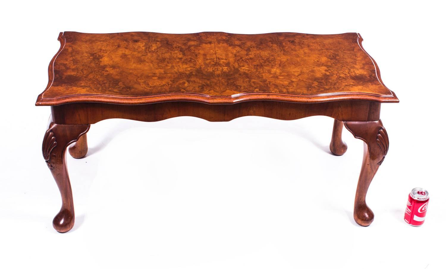 This is a stunningly beautiful English burr walnut coffee table, with a beautiful shaped top and dating from the mid-20th century.

It stands on four elegant solid walnut hand-carved Queen Anne style legs which
set against the rich texture of the