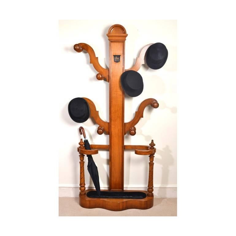 This is a stylish Victorian solid oak hall stand, circa 1860 in date. 

The central pilaster is mounted with a painted shield and decorated with a lion crest. There is ample space to accommodate your coats, umbrellas and walking sticks and the