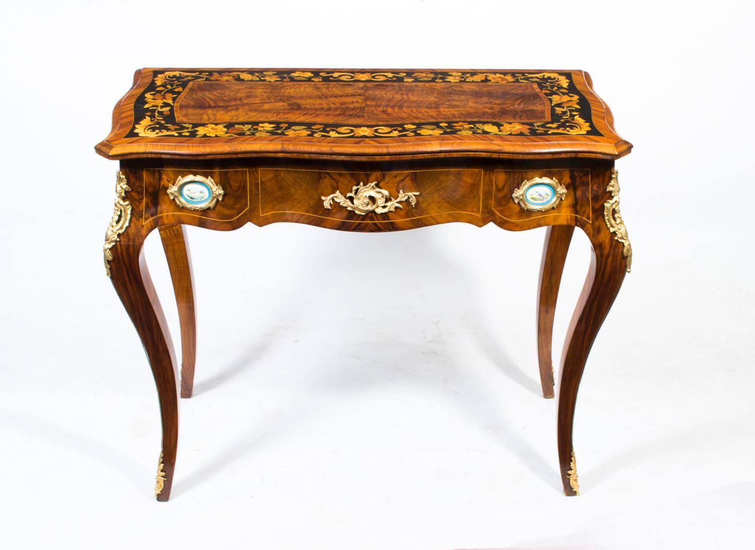 This is a stunning late 19th century antique French burr walnut card table with ormolu mounts, circa 1860 in date.
 
The burr walnut top has kingwood crossbanding encompassing exquisite floral marquetry on an ebonised ground.

It has two