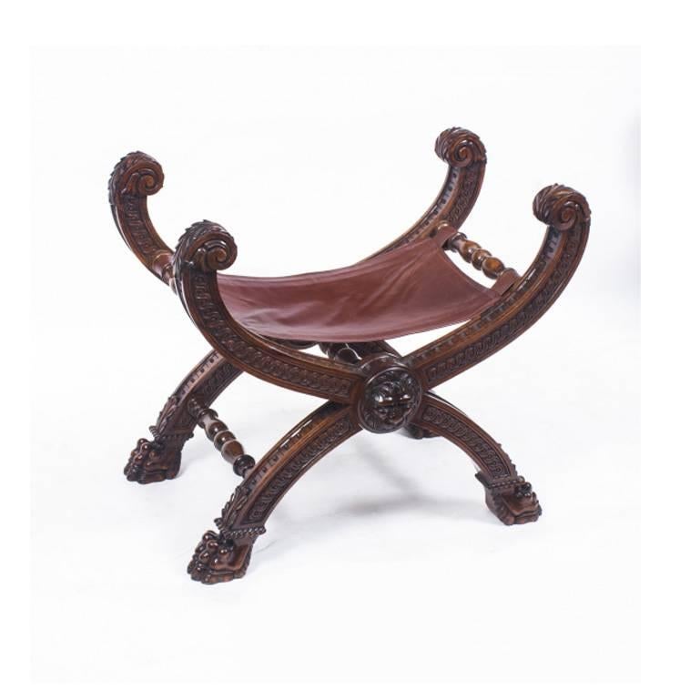 This is a beautiful antique pair of Gothic Revival walnut X-frame folding stools, circa 1860 in date and in the manner of A.W.N.Pugin.

Each superbly upholstered leather seat is on hand carved solid walnut folding X-frames, each centred with a